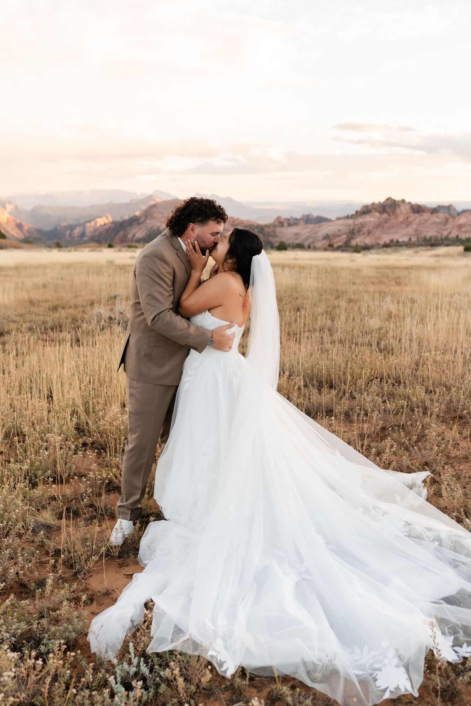 A dramatic dip pose captured during a wedding photoshoot in a mountain field.