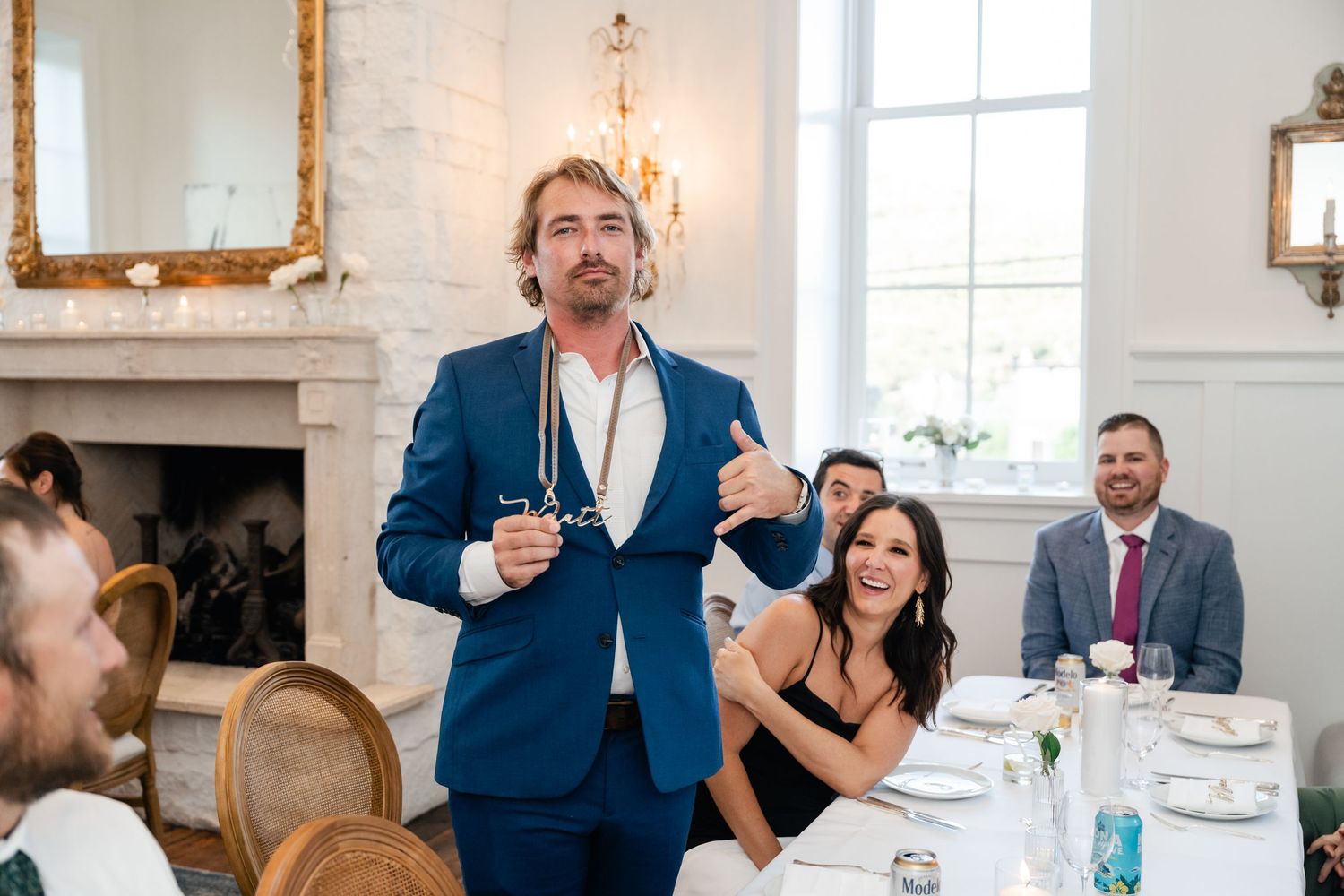 Wedding guests enjoying a bright indoor reception space with elegant decor and natural lighting.