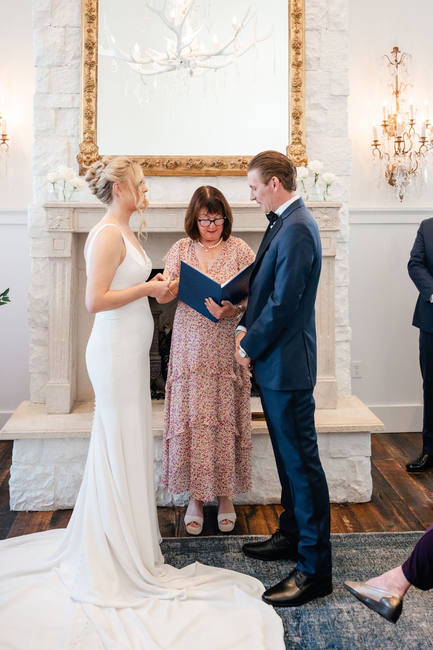 Intimate wedding ceremony moments unfold in an elegant white chapel with gold accents and chandeliers.