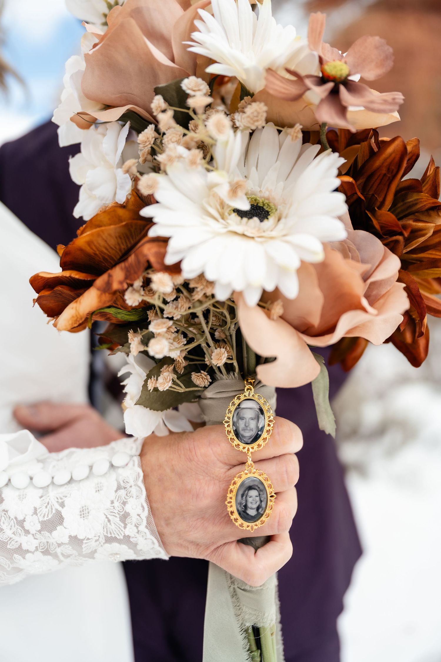 A bridal bouquet with white gerbera daisies, peach roses, and vintage locket details.