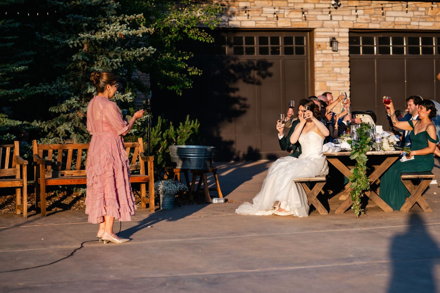 Wedding celebration on an outdoor patio with guests dancing in evening light.