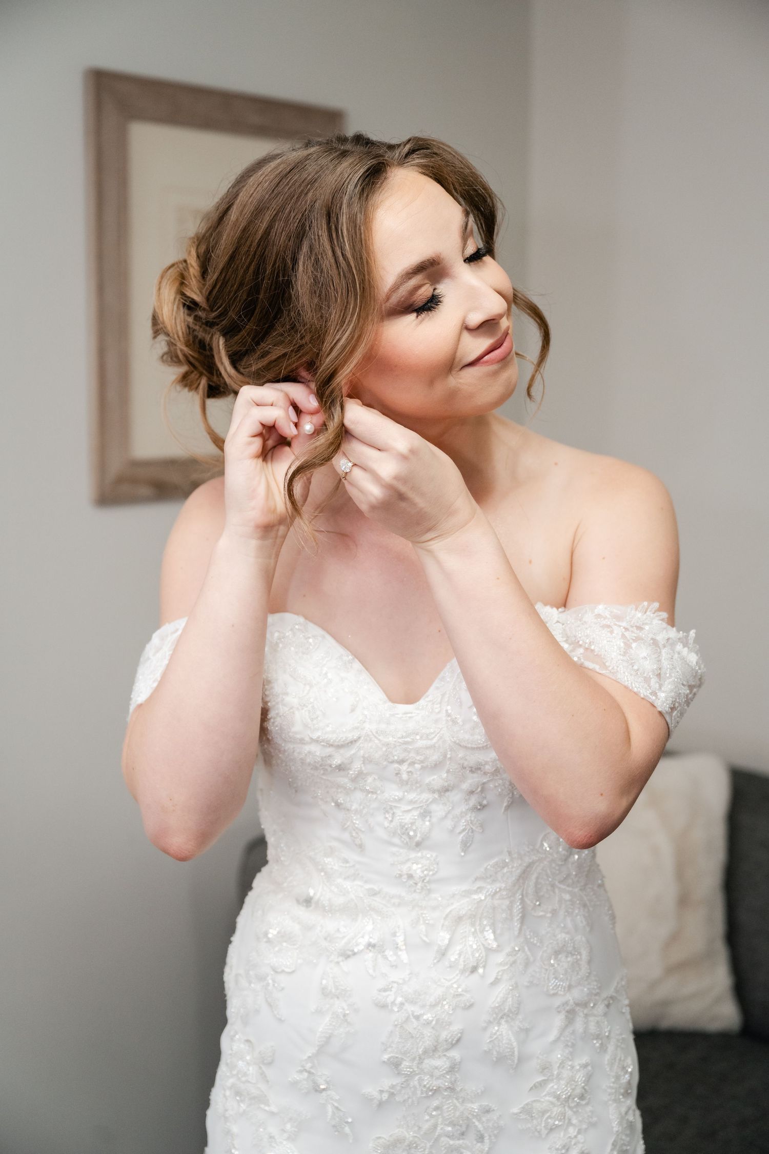 A series of photos showing a bride in a white lace wedding dress putting on earrings while getting ready. Millcreek Inn Wedding
