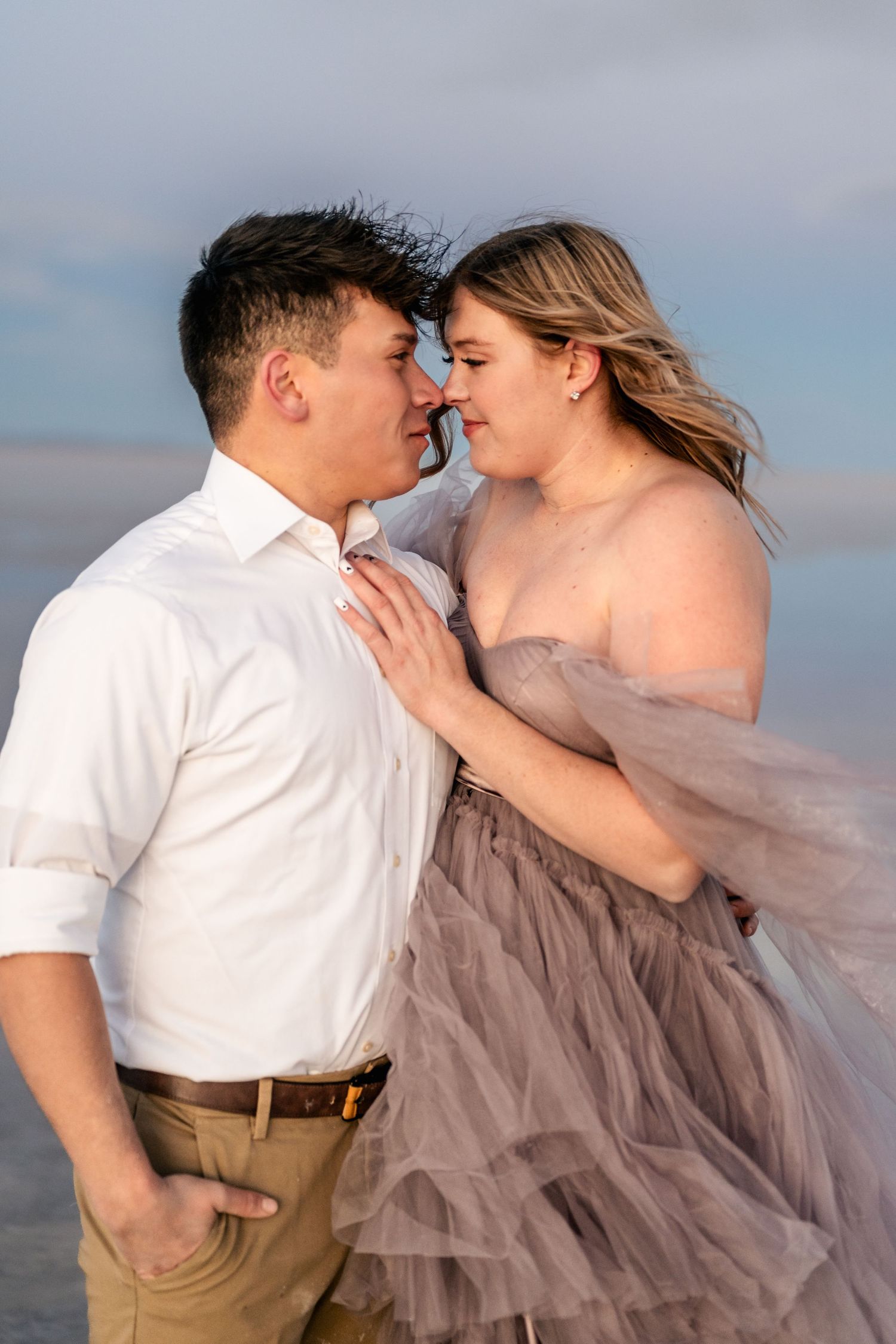A tender embrace between the couple, illuminated by the soft blue light of blue hour at the Salt Flats.