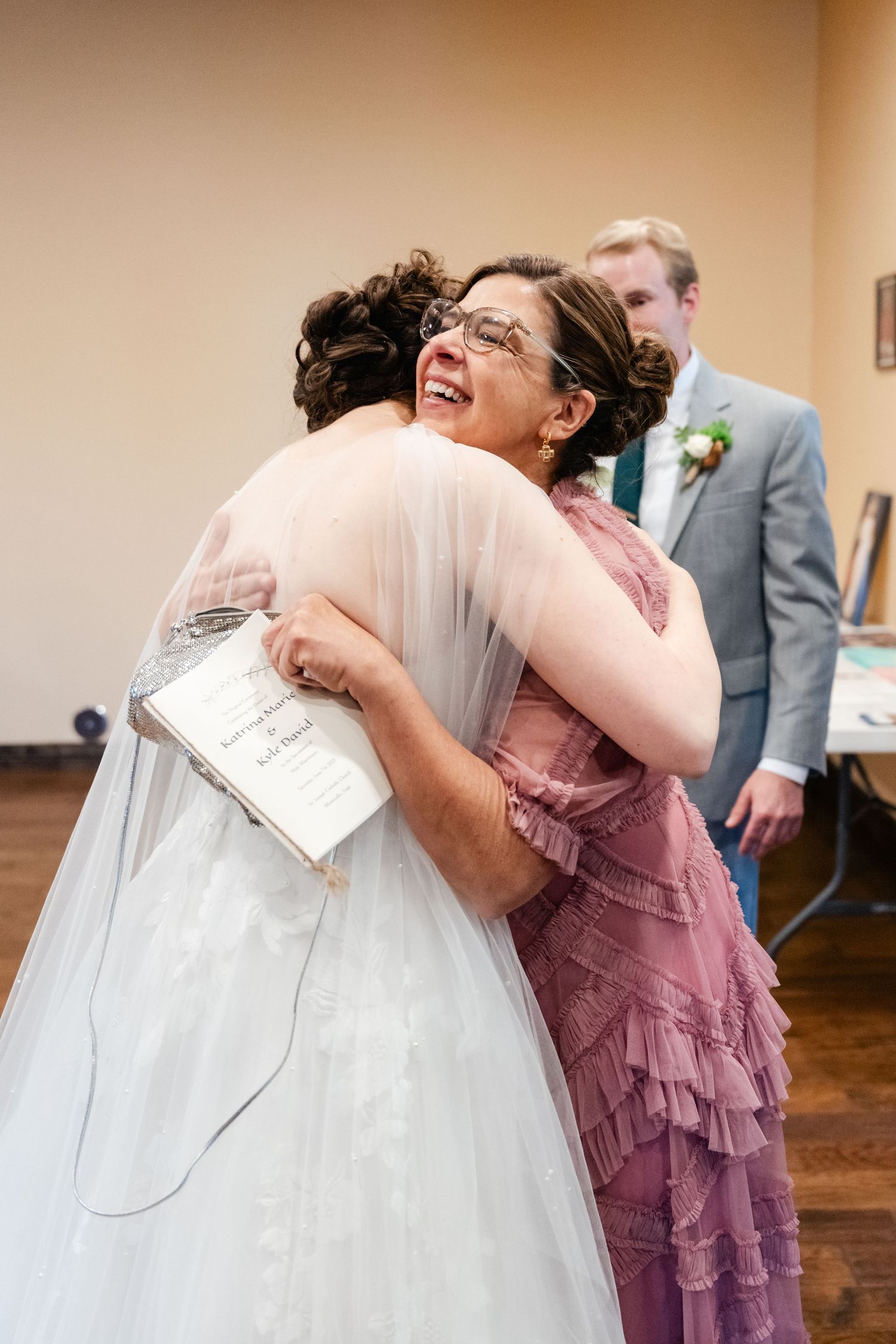 Emotional wedding moment showing embraces in formal attire.
