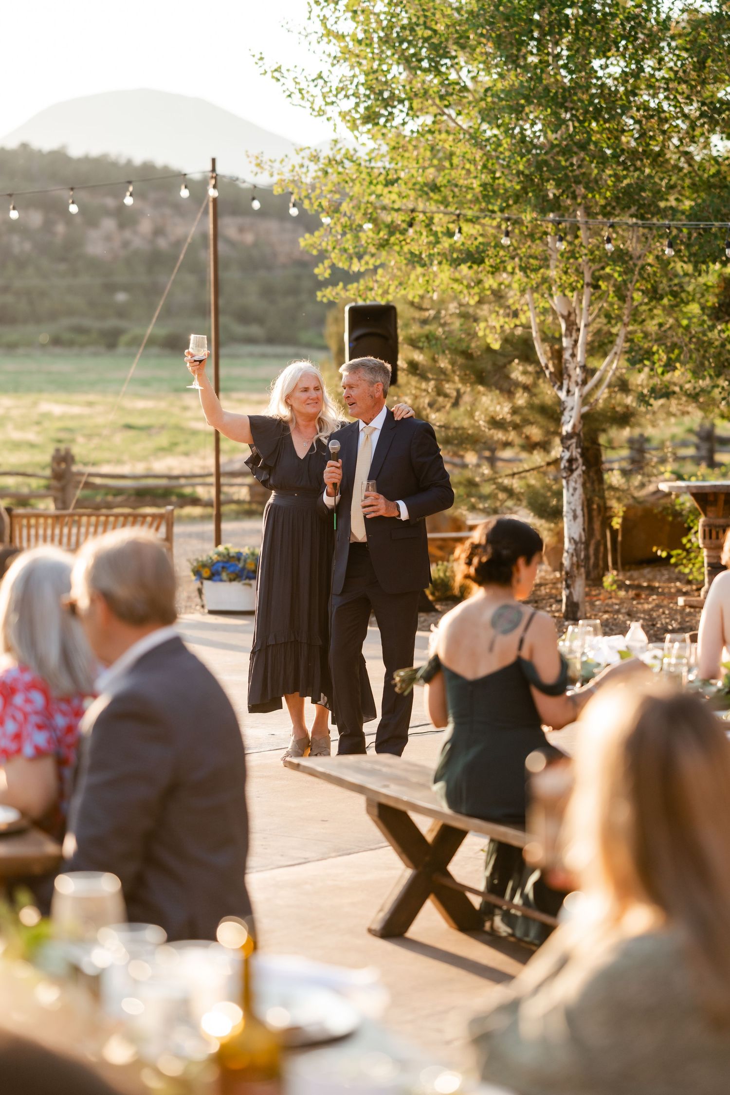 Wedding guests enjoying outdoor dancing and festivities during golden hour.