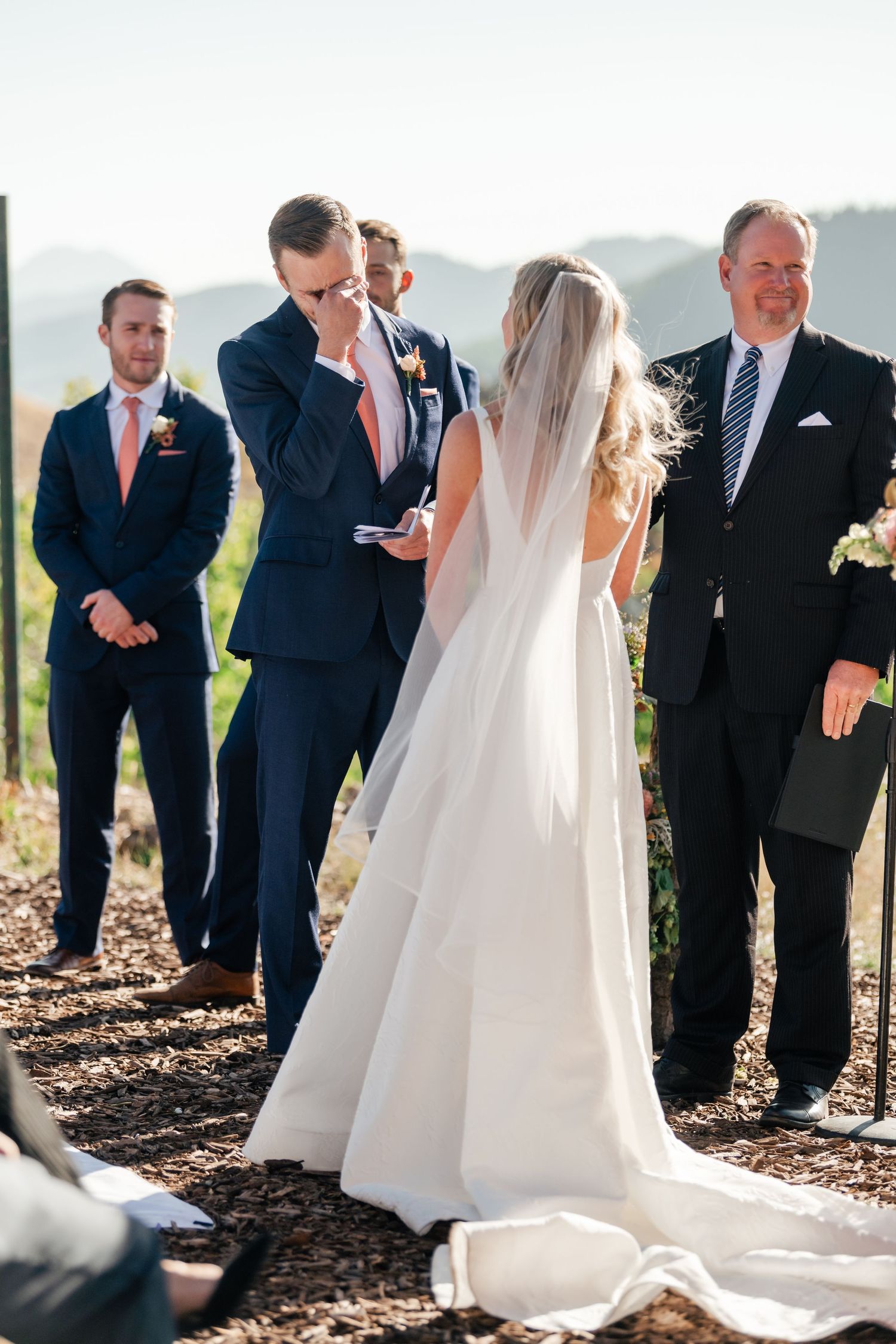 Outdoor wedding ceremony taking place against a scenic mountain backdrop.