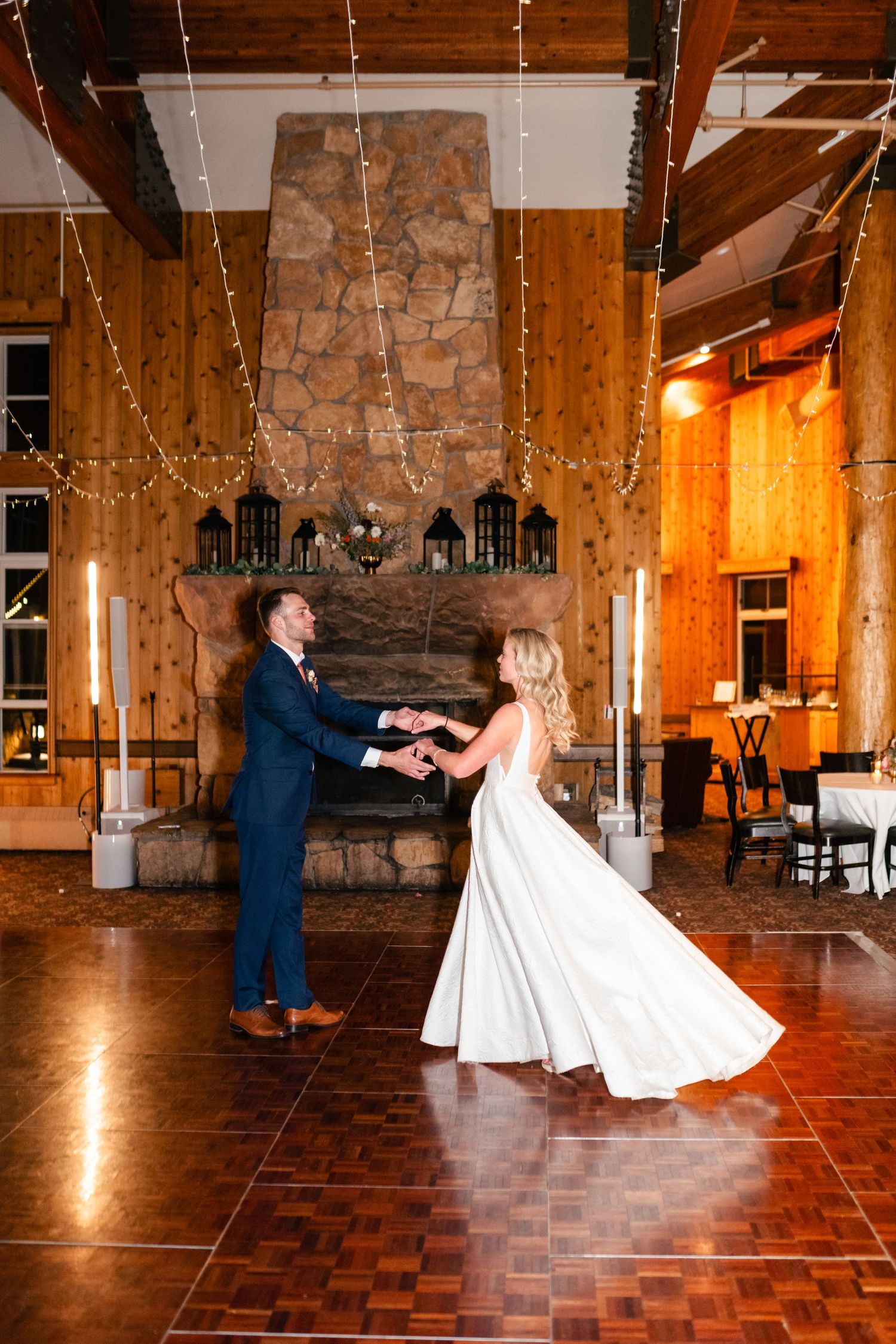 Wedding couple performs dramatic dance moves on a wooden dance floor.