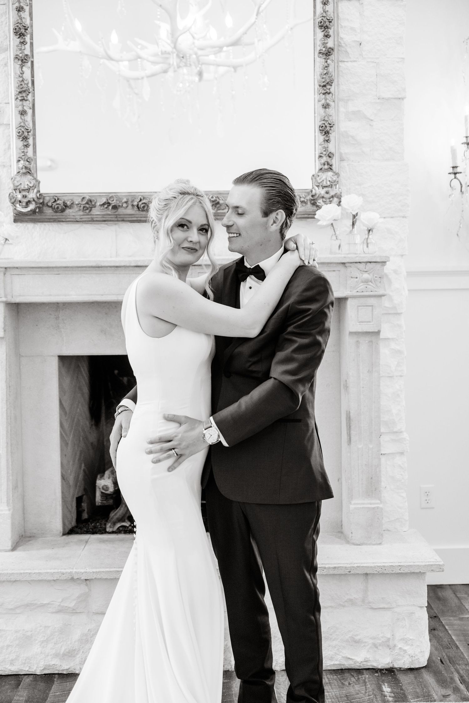 Black and white photo of a couple dancing in an elegant white interior space.