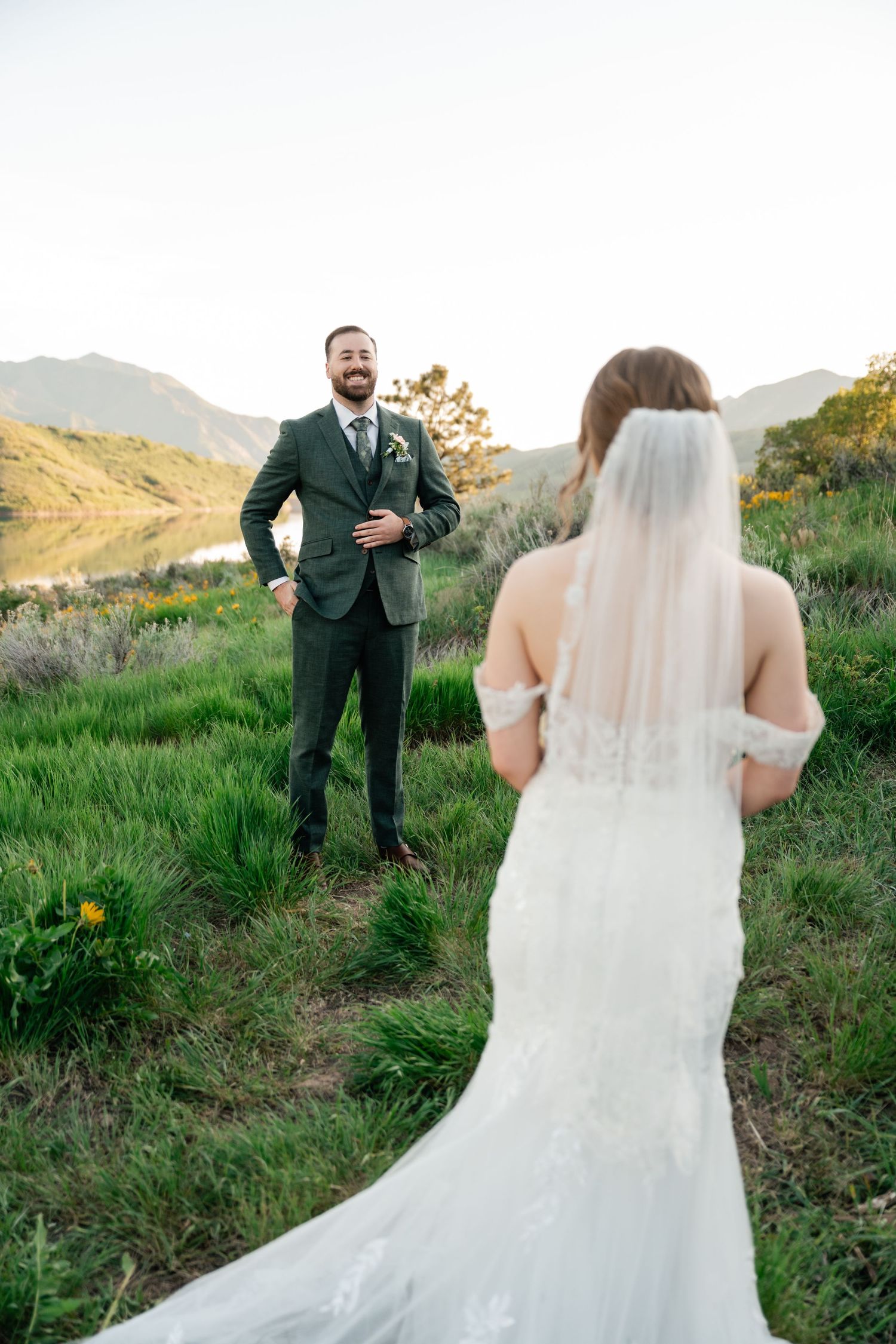 A wedding first look moment captured on a hillside trail surrounded by natural greenery.