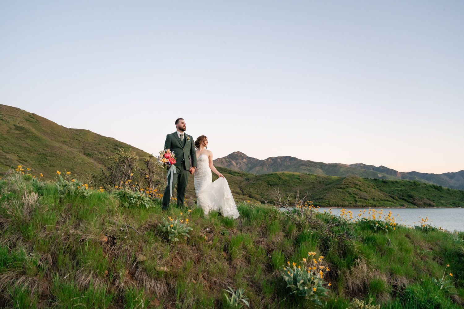 Panoramic wedding photos captured against rolling hills and mountain landscape at sunset.