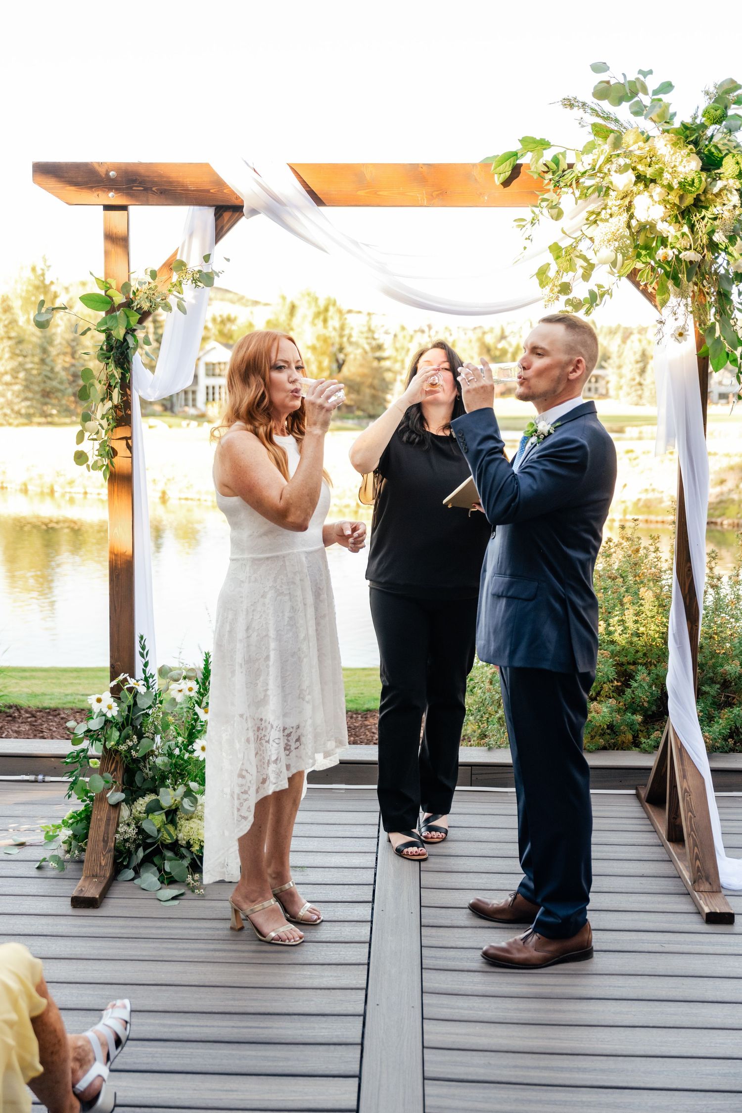 A couple shares a lighthearted moment with the officiant during their wedding ceremony.