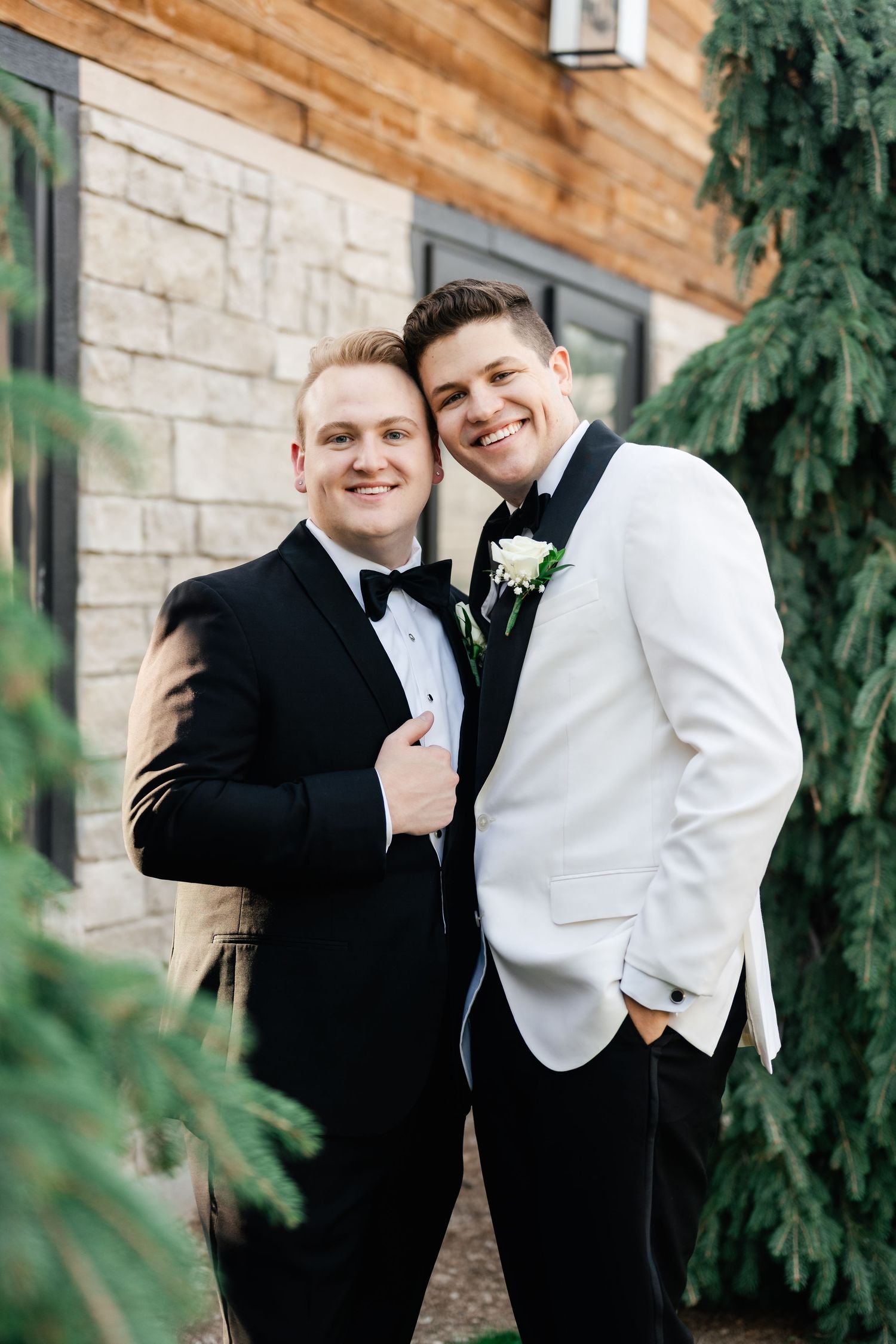 Two grooms in formal wedding attire share a joyful embrace at Highland Gardens. LGBTQ wedding photographer in Utah. Utah Gay wedding photos