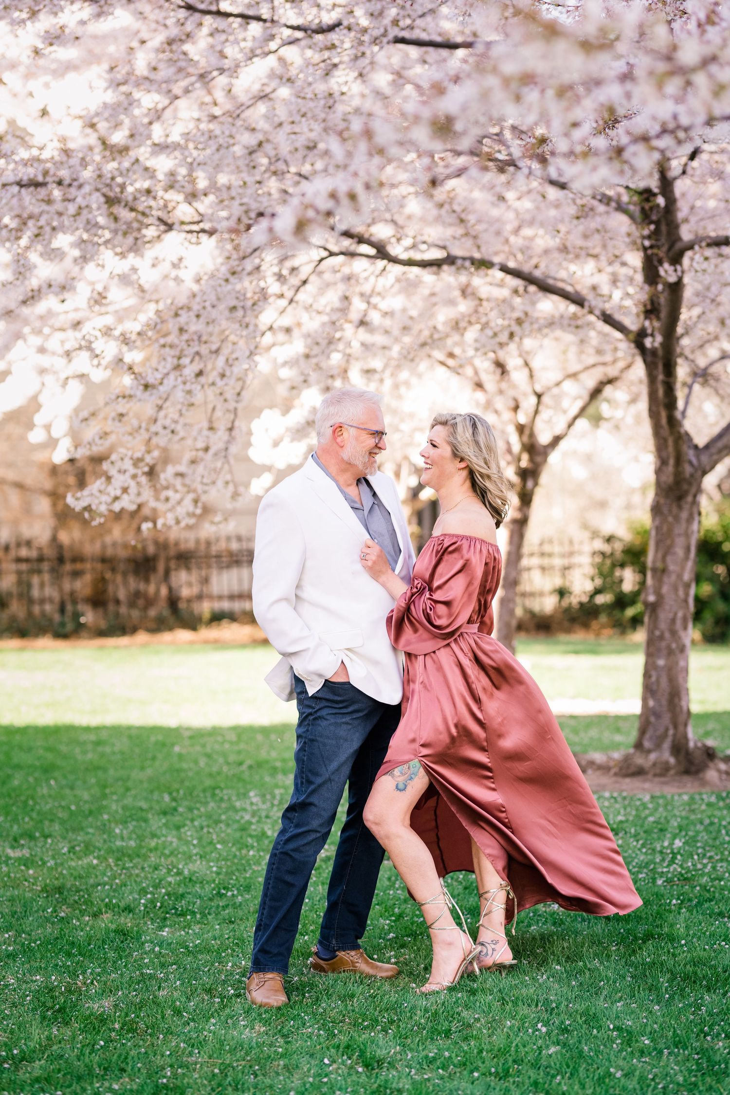 Engaged couple dance together under the blossoms at the Utah State Capitol by Utah engagement photographer Coley Cook
