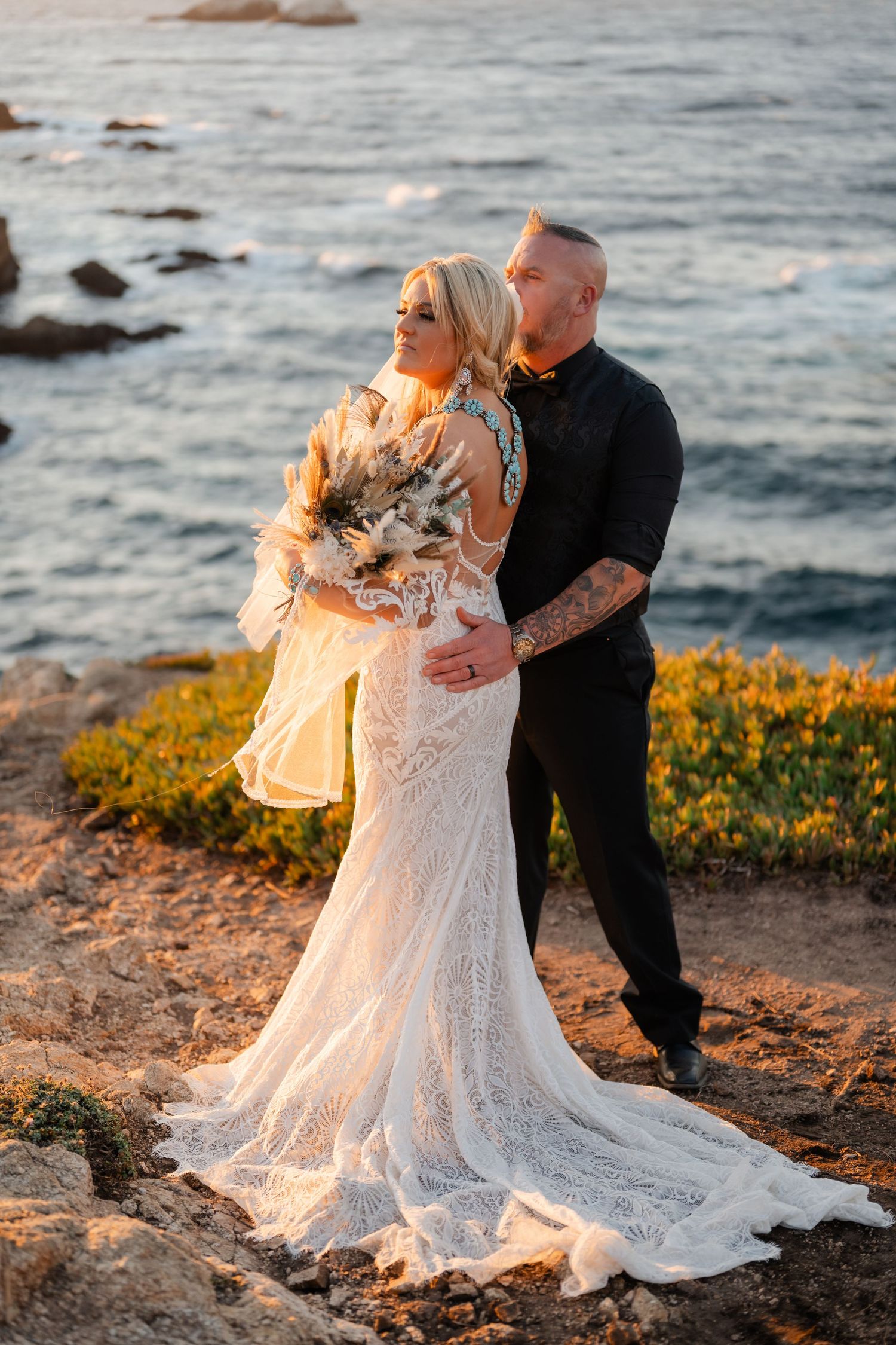 Golden hour wedding portraits on California coast with dramatic ocean backdrop.