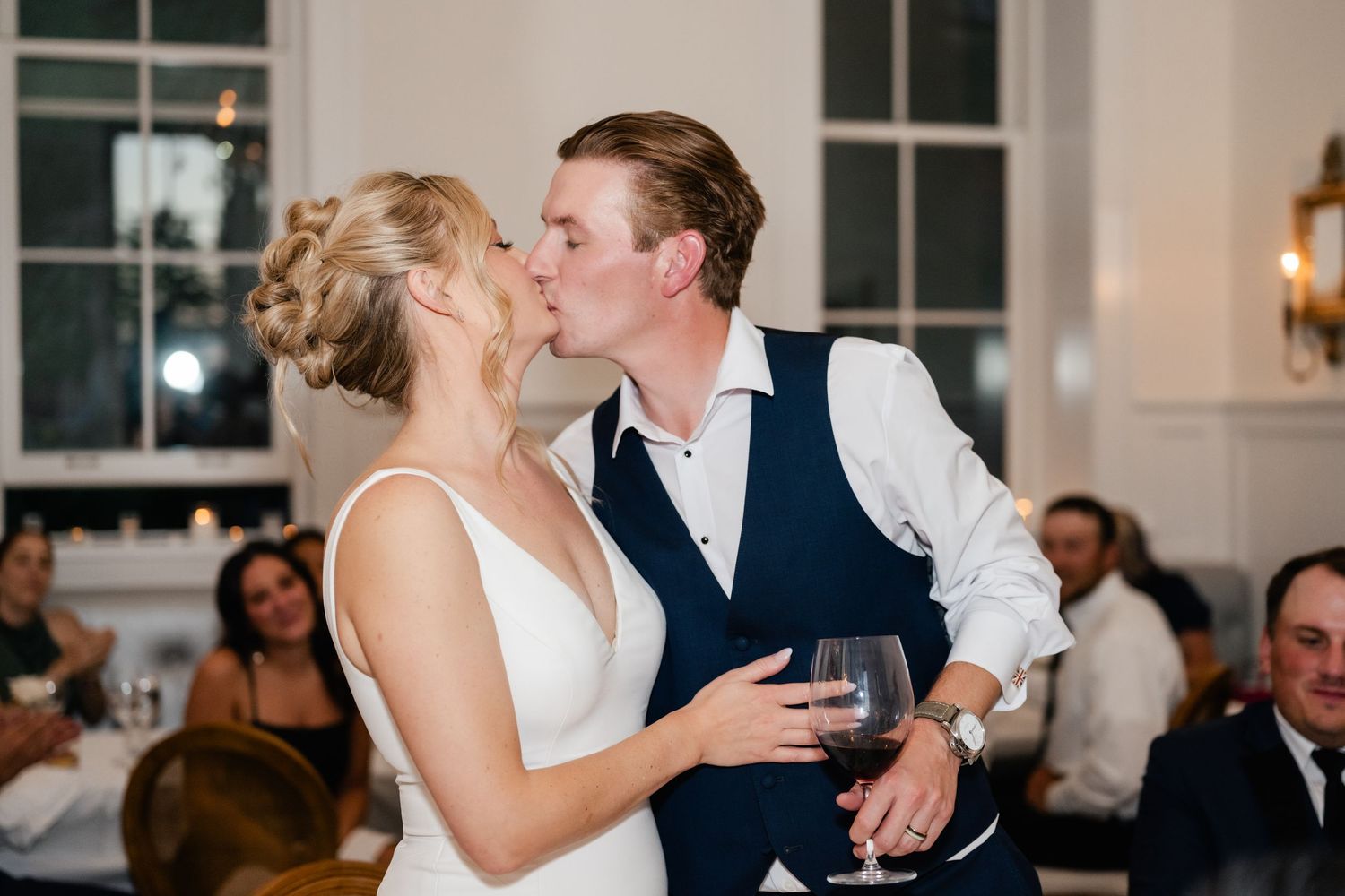 Wedding reception guests share intimate moments during evening celebration.