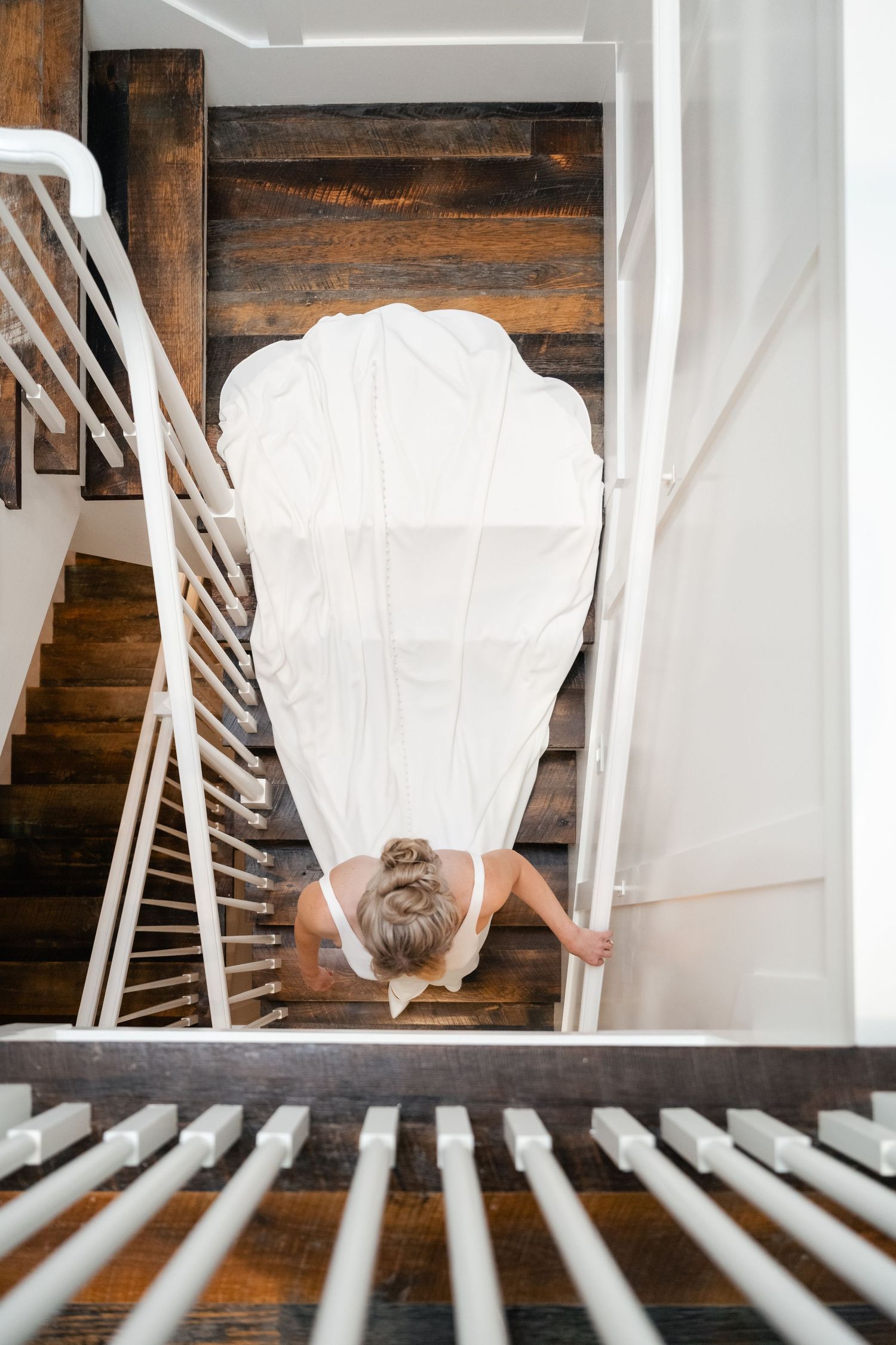 A series of photos showing a white wedding dress veil flowing down wooden stairs.