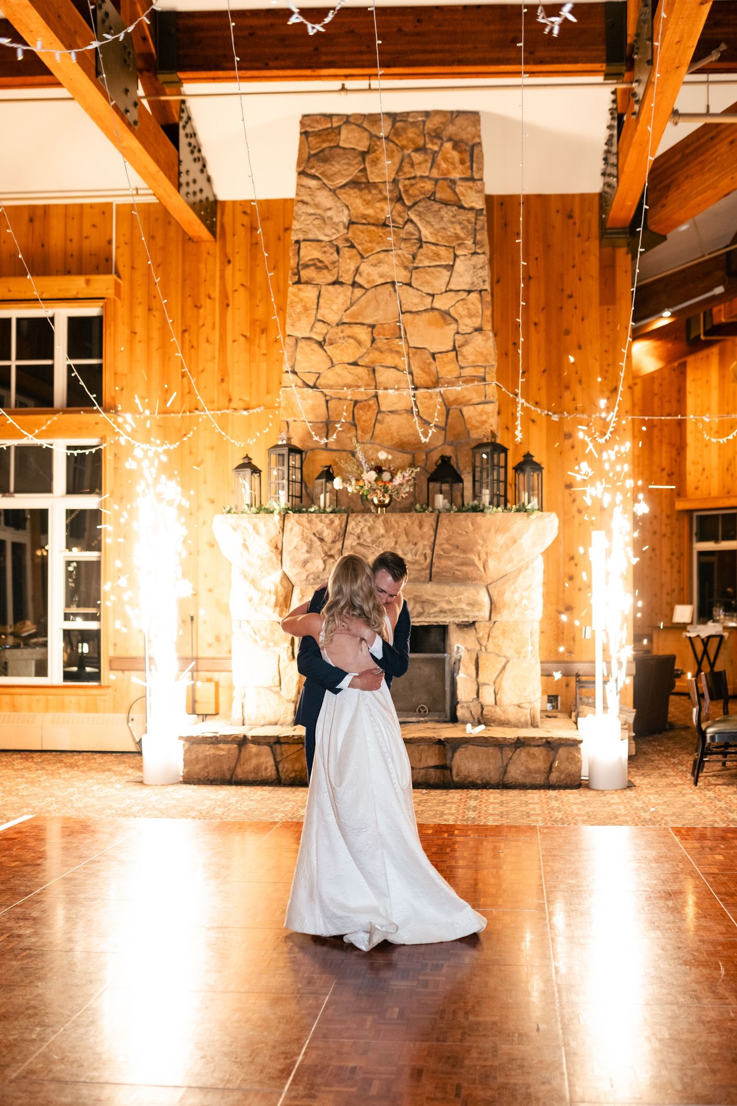 Wedding dance sequence in a rustic stone and wood venue illuminated by warm lighting.