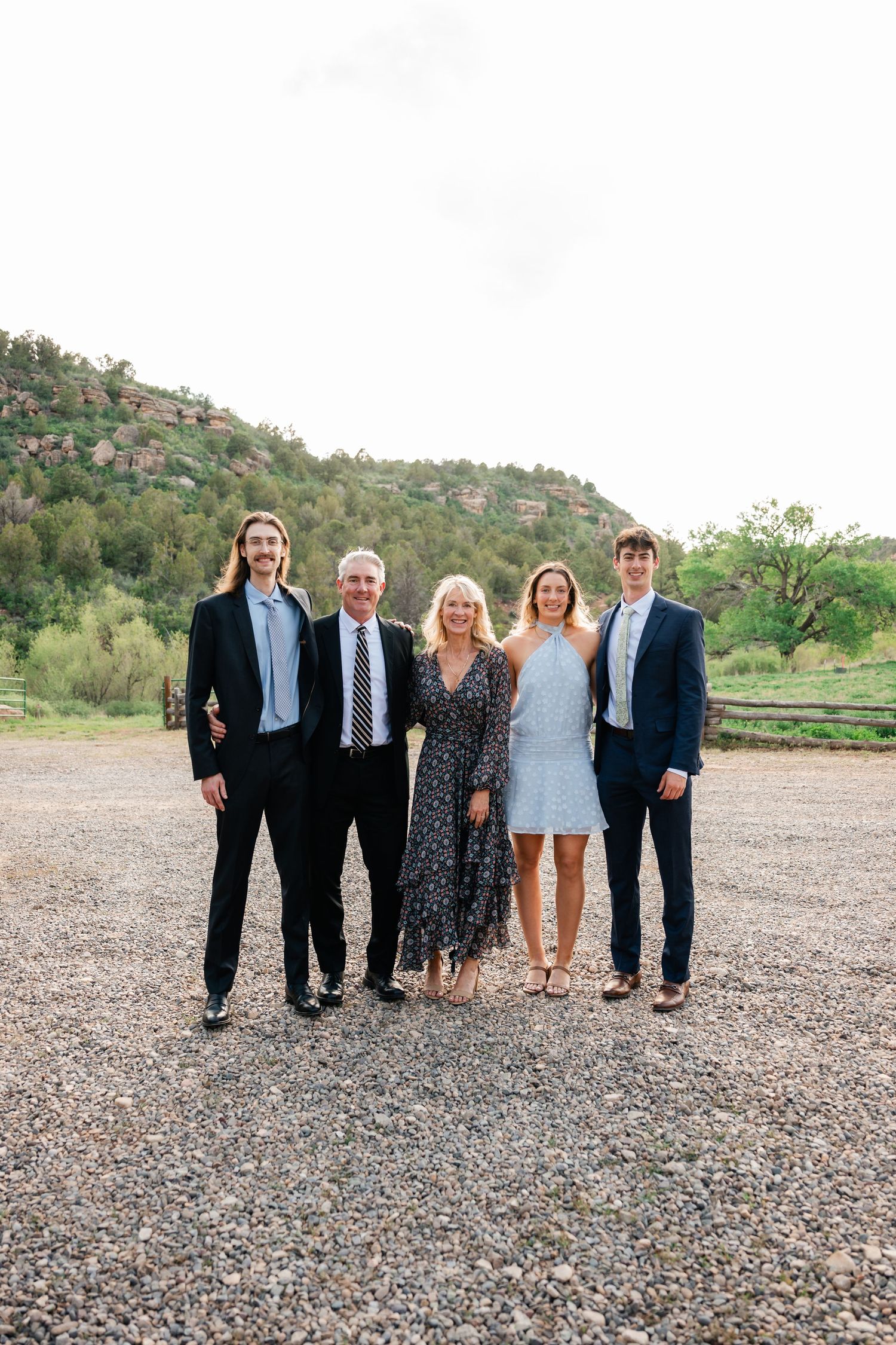Family group poses for formal portrait in front of desert mountain landscape.