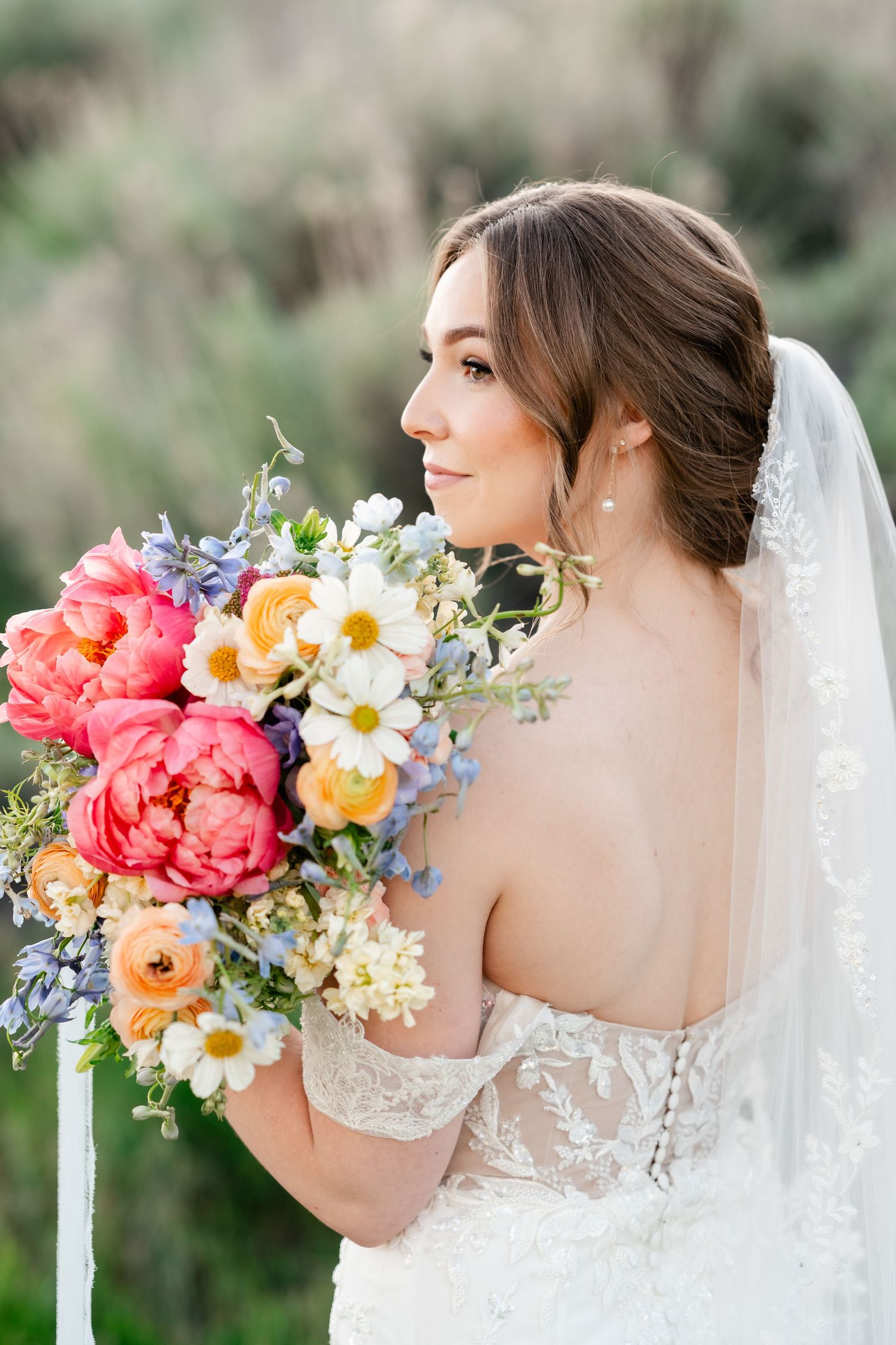 Bridal portrait series showing colorful spring bouquet with coral peonies, daisies and delicate veil details.
