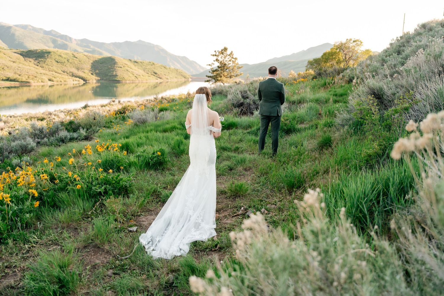 A scenic mountainside wedding photography session with figures in formal attire against a natural landscape backdrop.