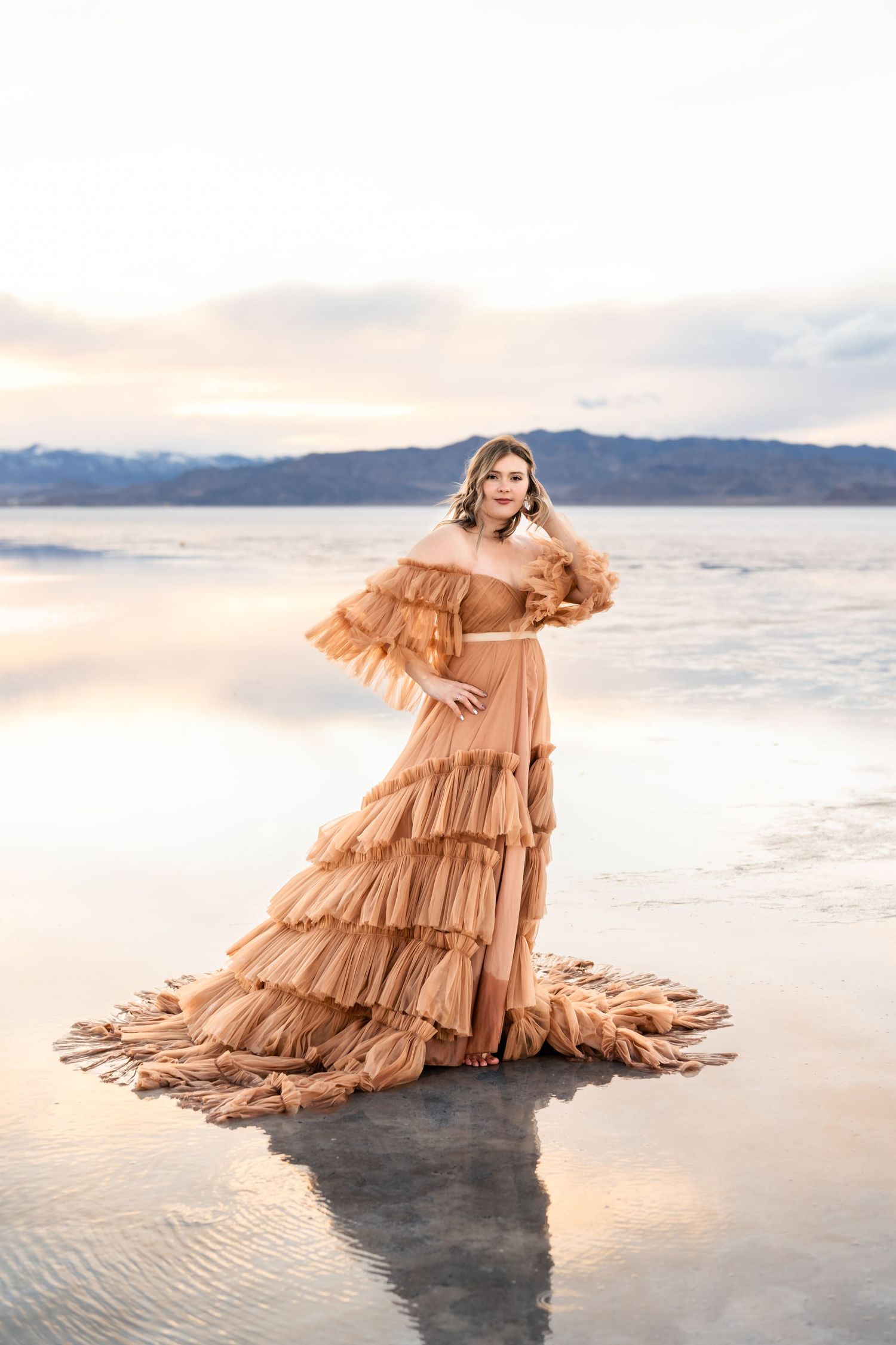 The flooded Salt Flats provides a captivating backdrop for a couple's photo session during golden hour