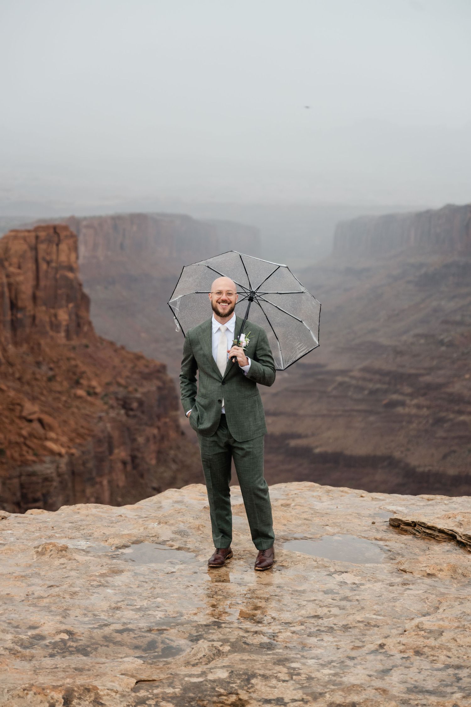 A series of photos showing a person in a green suit with an umbrella standing on a cliff edge at a canyon overlook.