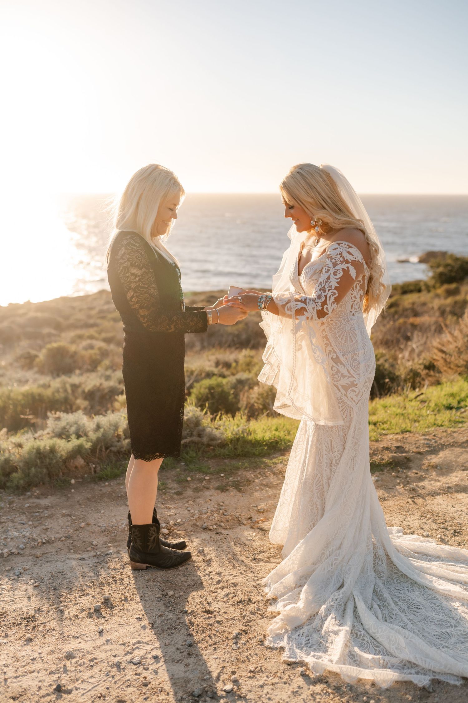 A couple shares an intimate moment on a coastal cliff during golden hour.