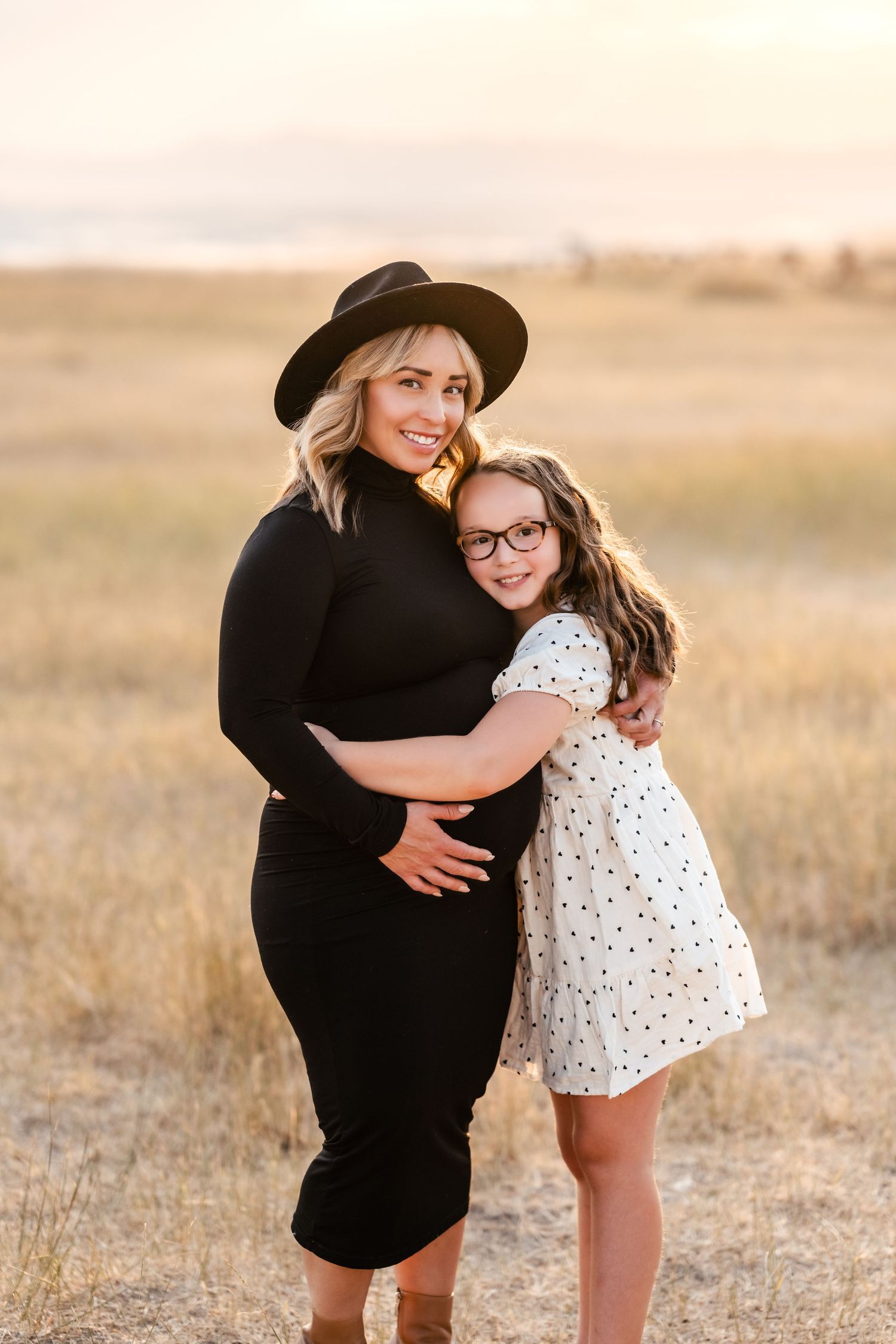 Tender embraces shared in a warm sunlit field during an intimate photo session.