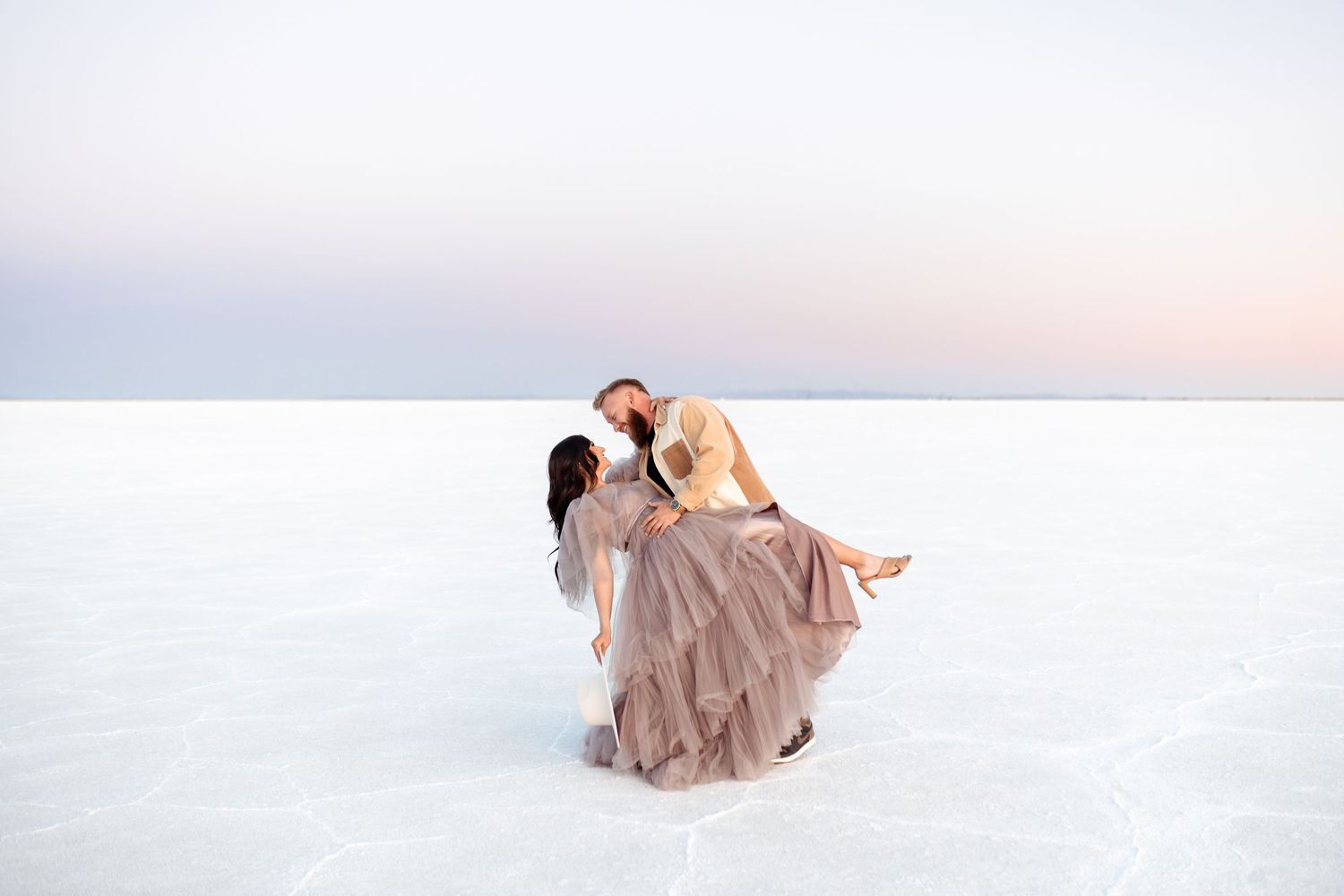 Utah Salt Flats Photographer. A dreamy portrait session features a flowing mauve dress against the ethereal backdrop of salt flats.