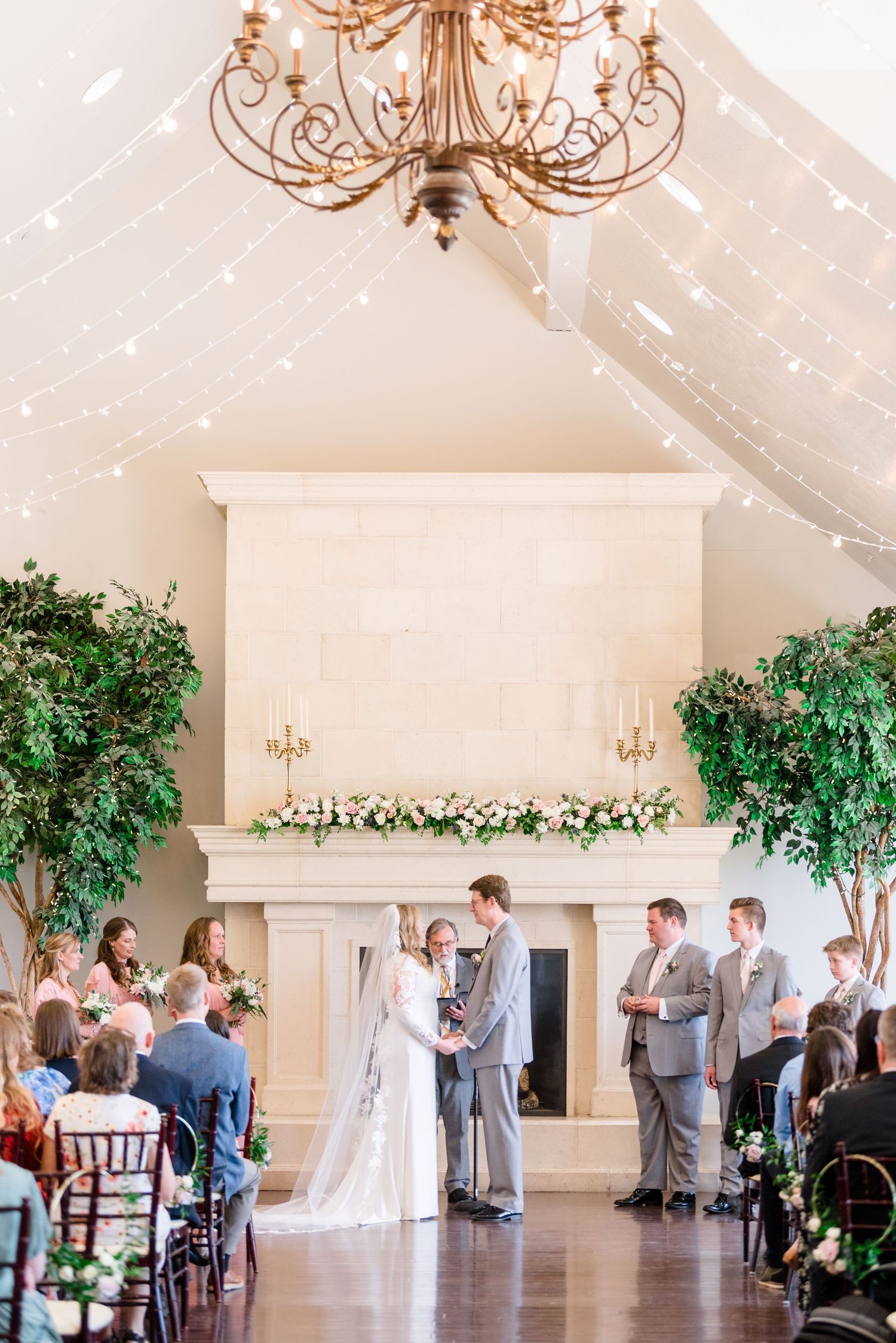 Wedding ceremony in front of large fireplace and natural light at Sleepy Ridge, a Utah County wedding venue.