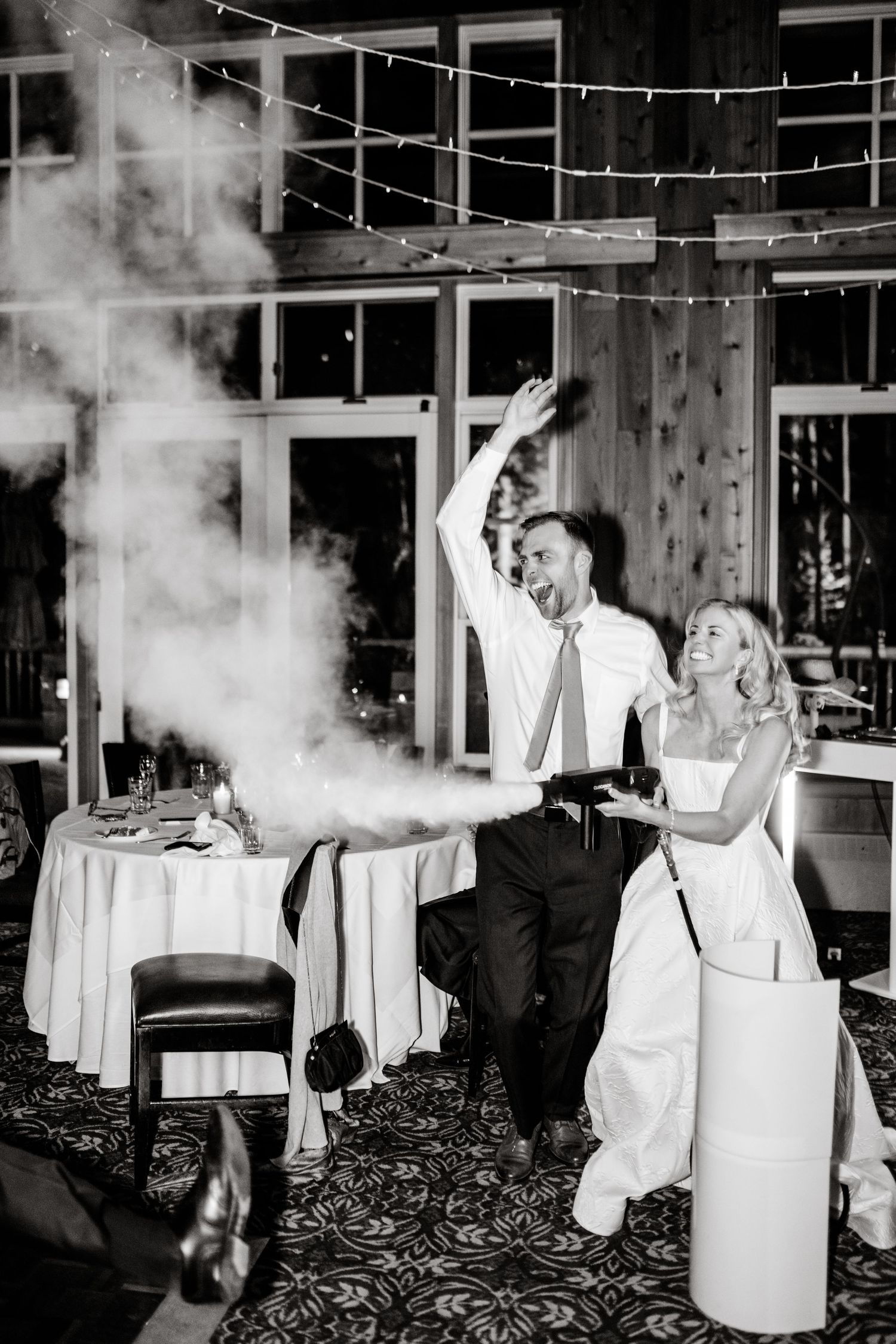 A lively reception moment with a burst of smoke and twinkling lights as a couple celebrates at their wedding. Utah Wedding Photographer.