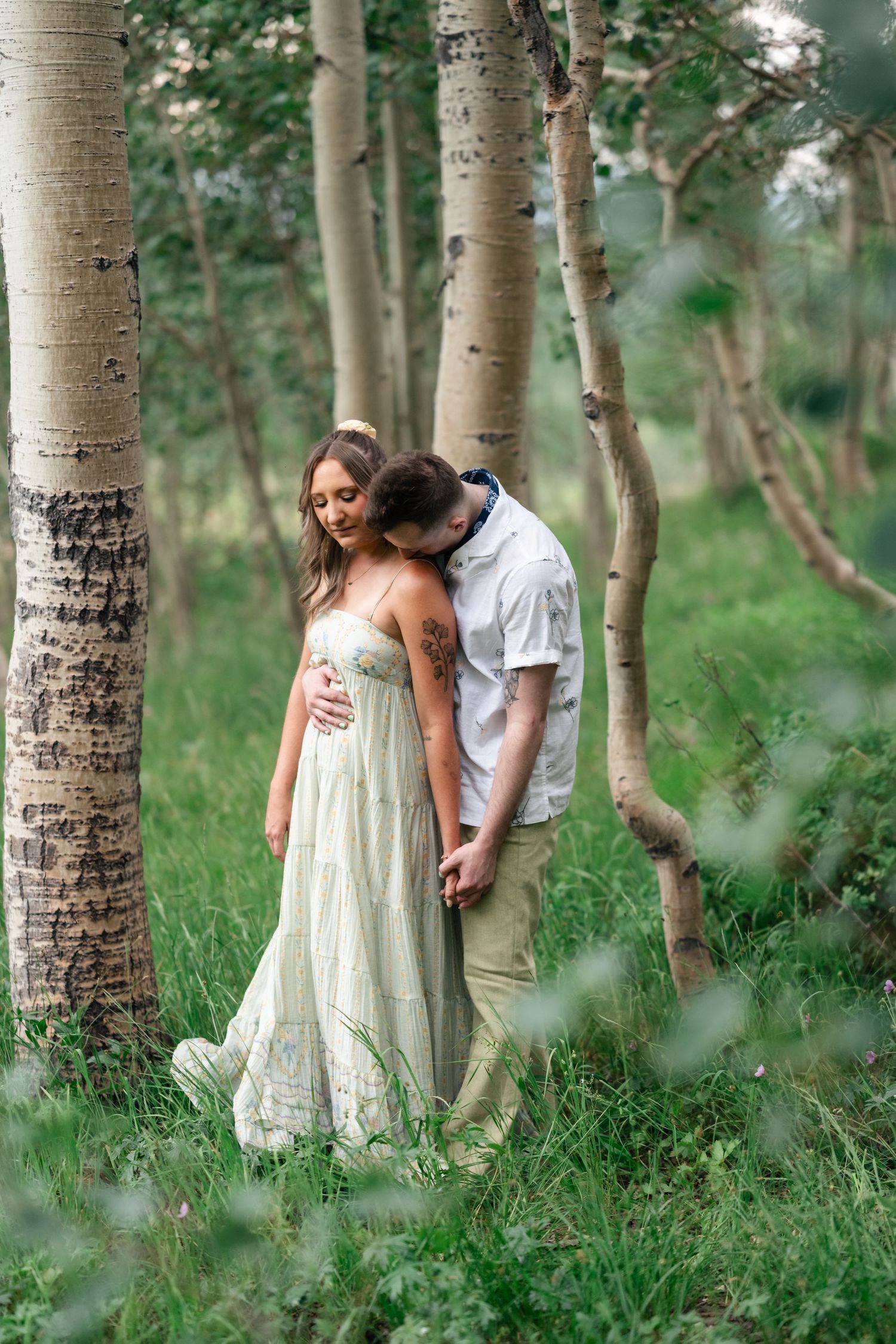 Romantic couple embraces among white birch trees in a dreamy forest setting with soft natural lighting. Park City engagement photographer