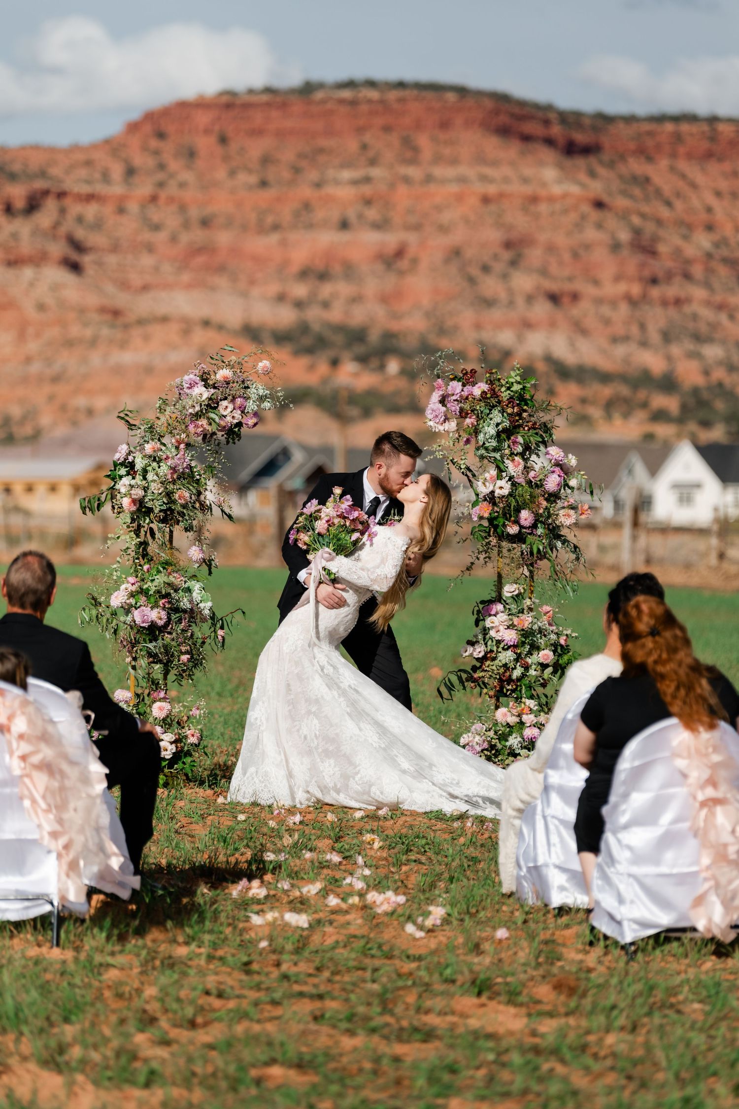 A wedding couple shares romantic moments in a series of photos against red rock cliffs and desert landscape. Zion Wedding Photographer.