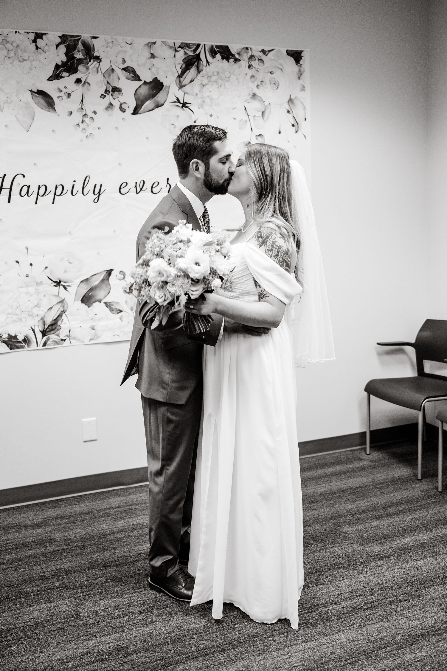 Black and white wedding photo series showing a couple dancing together in a room with decorative wall art.