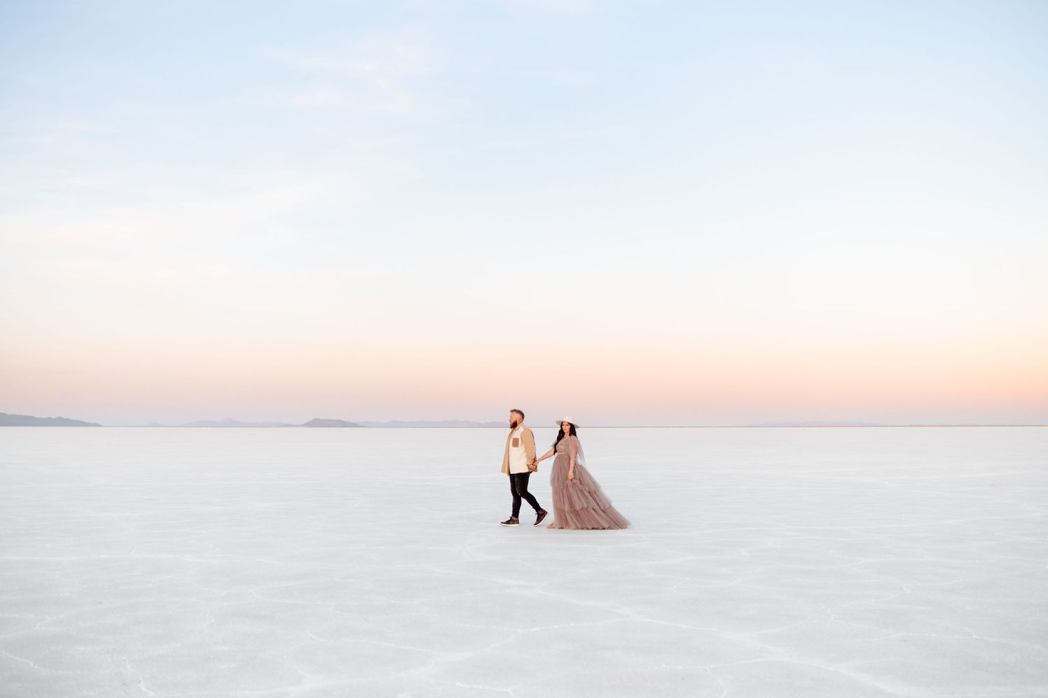 Couple walks on the Salt Flats during their couple session by Salt Flats photographer.