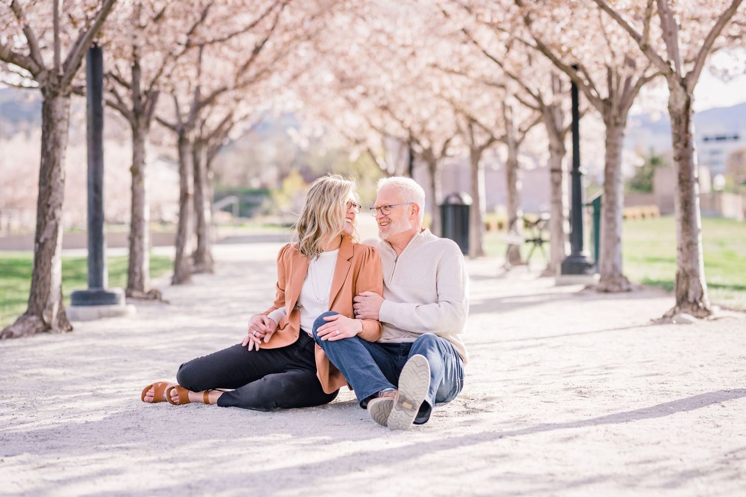 Couple sits together at the Capitol blossoms by Utah engagement photographer Coley Cook