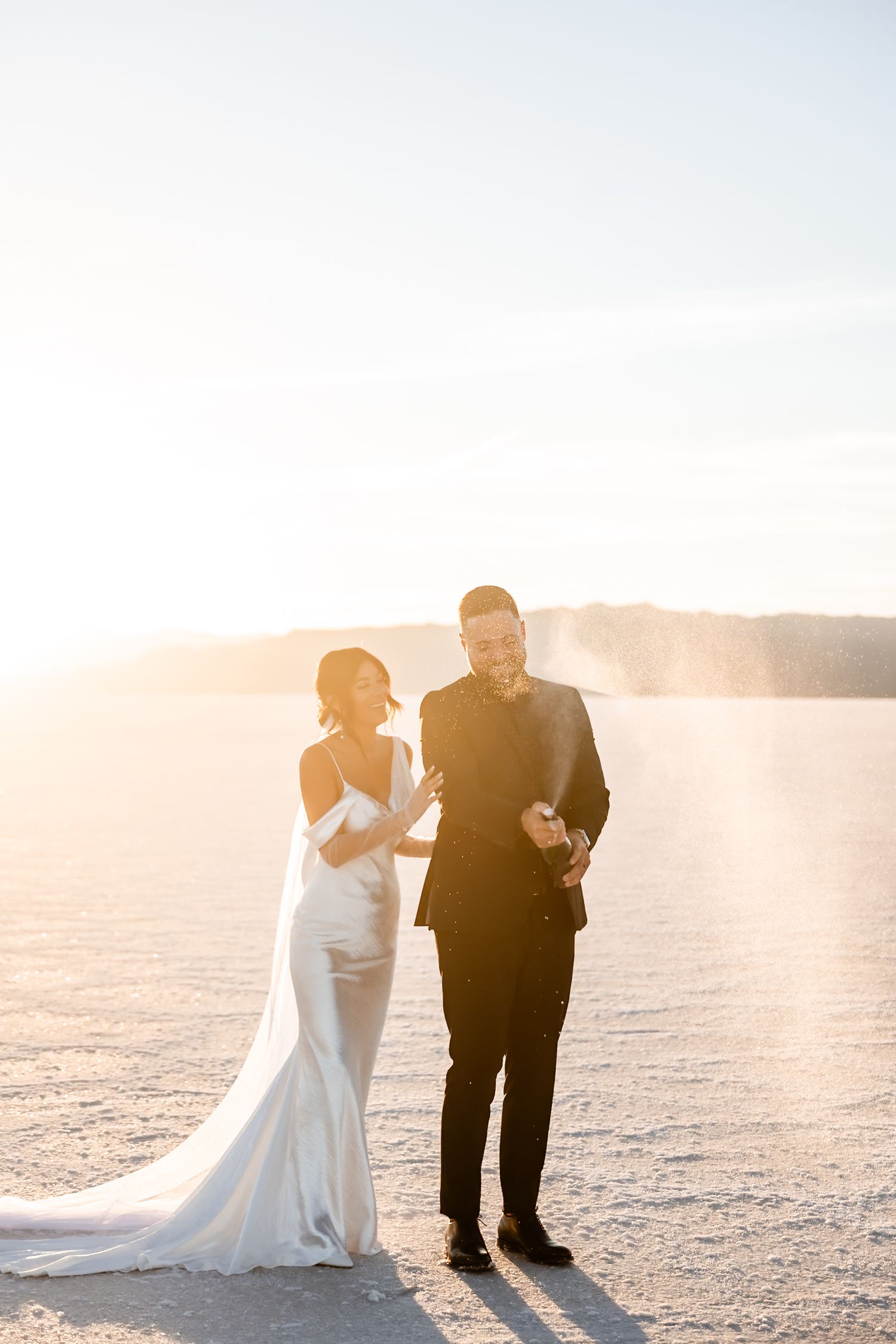 Romantic wedding photos on salt flats with golden sunset lighting.