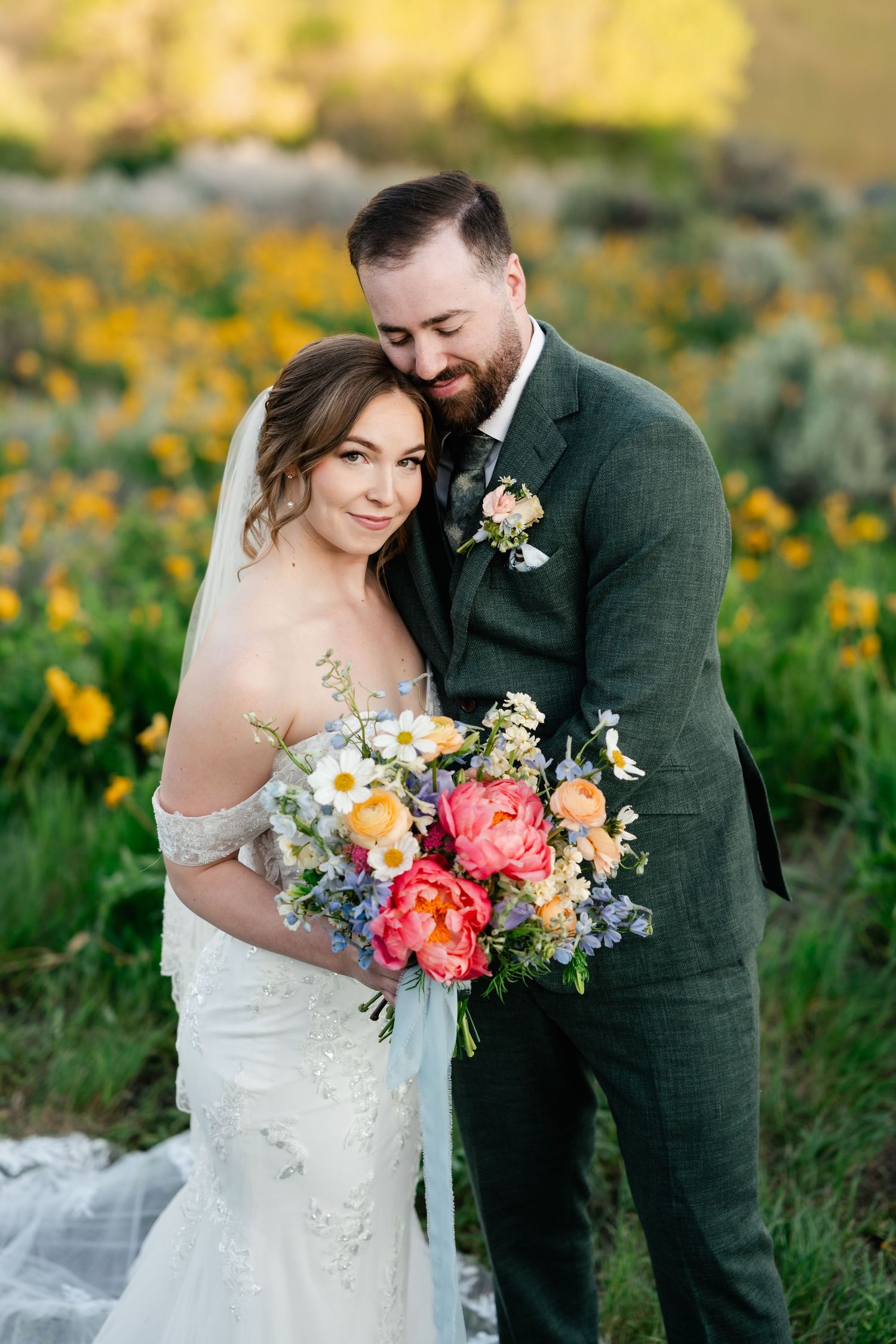 A romantic wedding photo shoot in a field of wildflowers with a colorful spring bouquet.