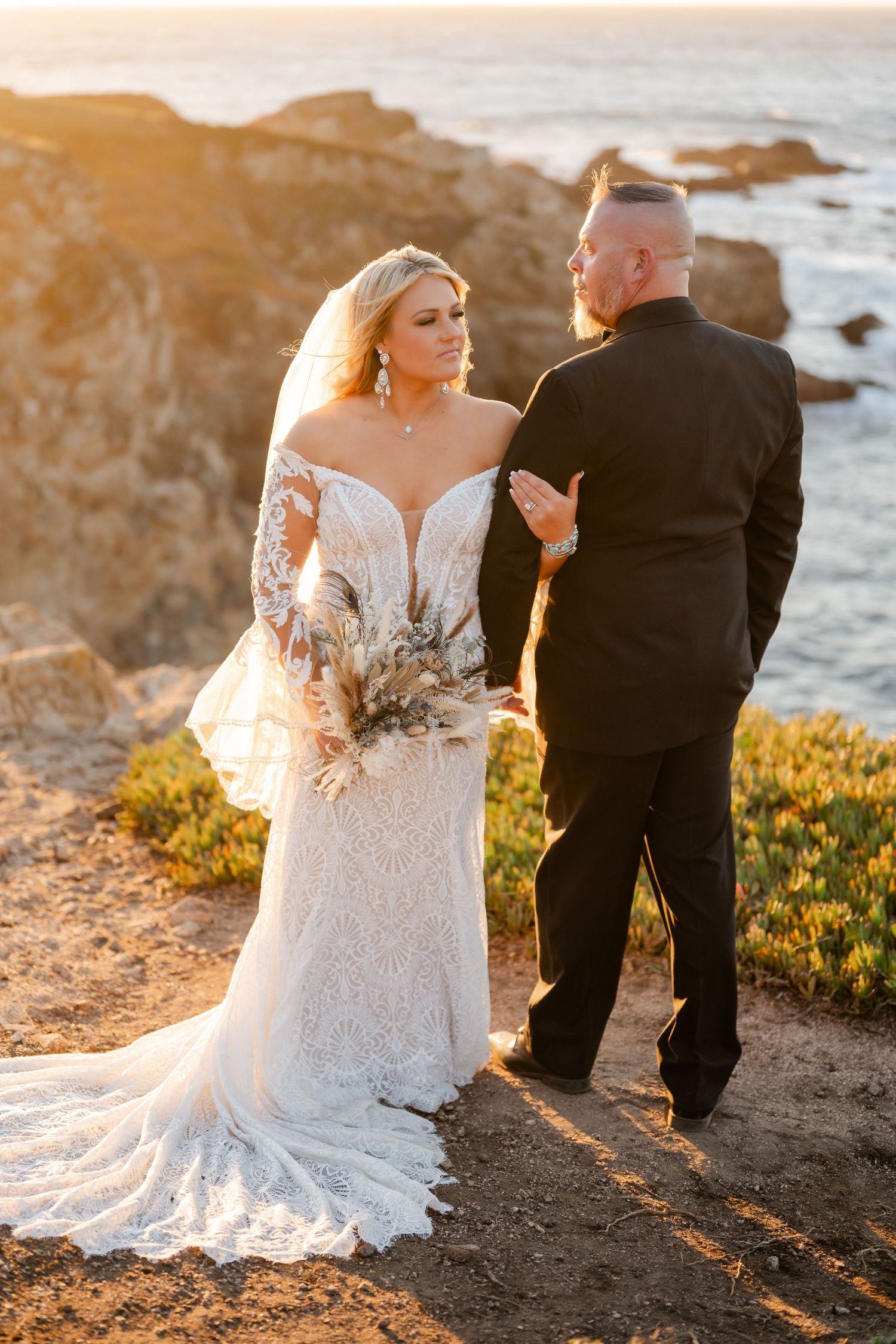 Wedding portraits captured on rocky coastal cliffs during golden hour.
