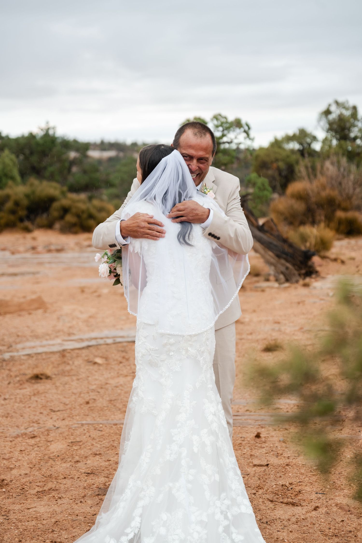 Wedding dress flowing in the wind against a desert landscape backdrop.