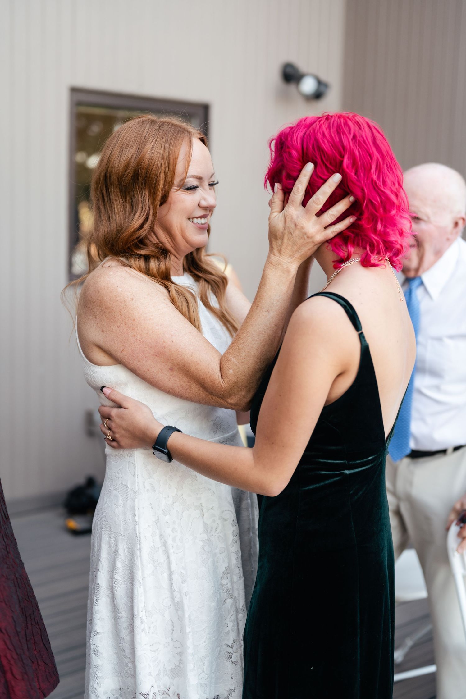 Two wedding guests share an emotional moment during celebration.
