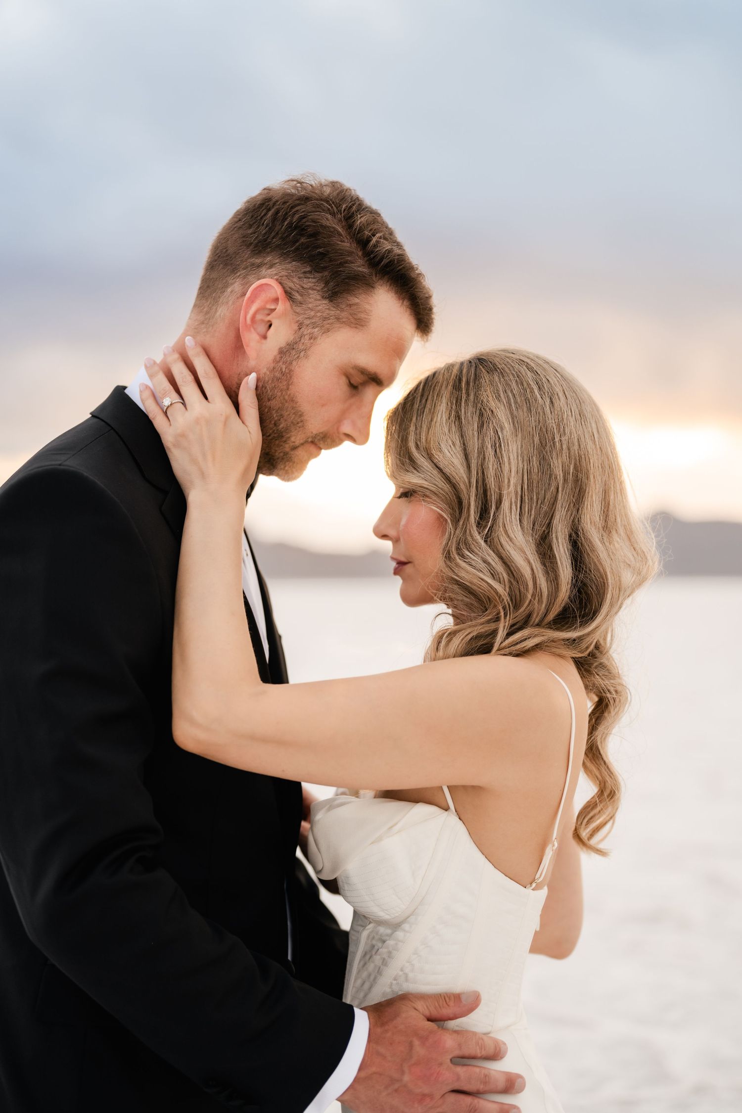 Salt Flats Elopement Photographer. Intimate wedding portrait session on salt flats with couple in formal attire embracing.