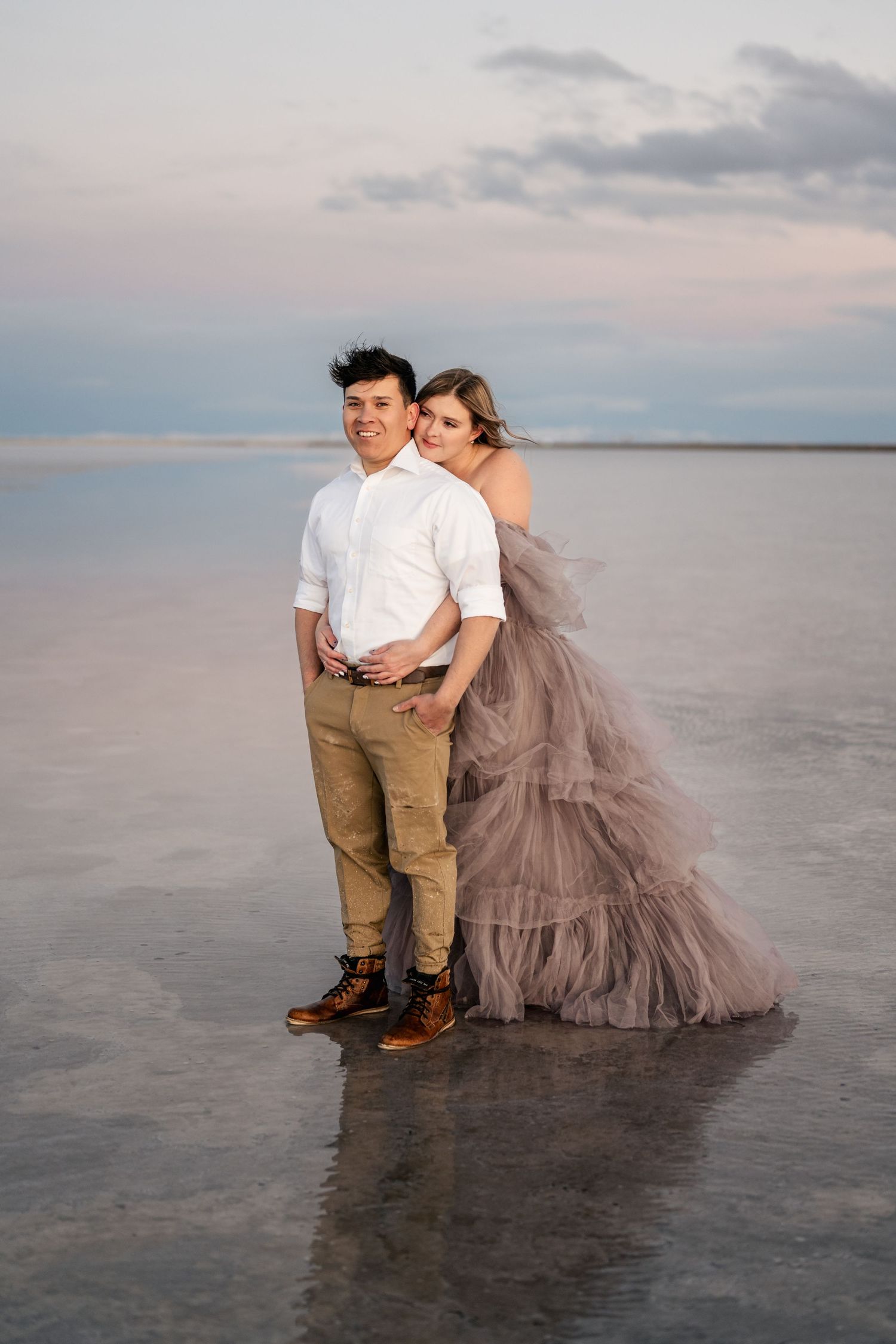 A tender embrace between the couple, illuminated by the soft blue light of blue hour at the Salt Flats.