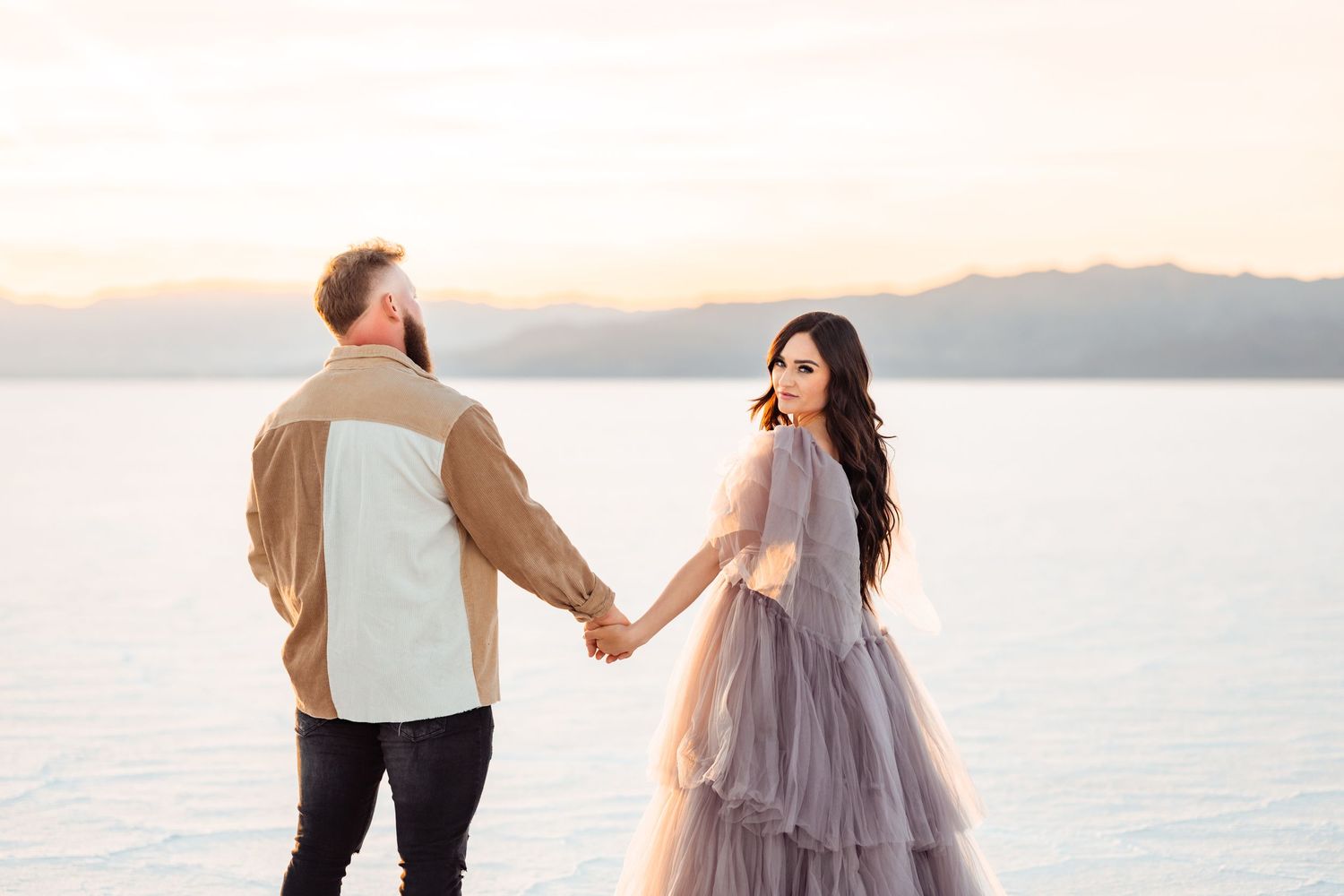 Couple holds hands during golden hour at the Salt Flats by Utah Salt Flats photographer