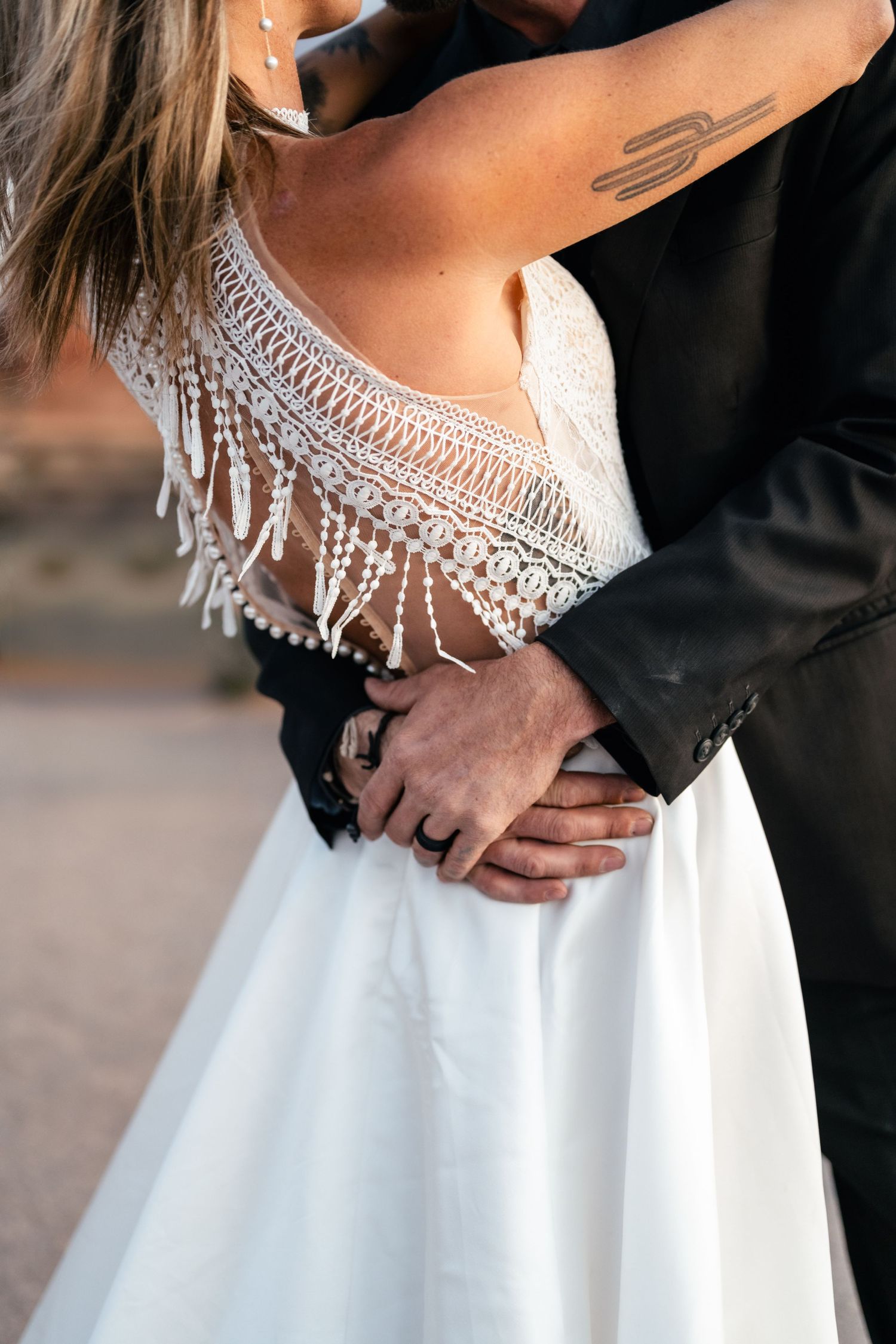 Detail photo of wedding couple holding close at Arches National Park by Arches Wedding Photographer
