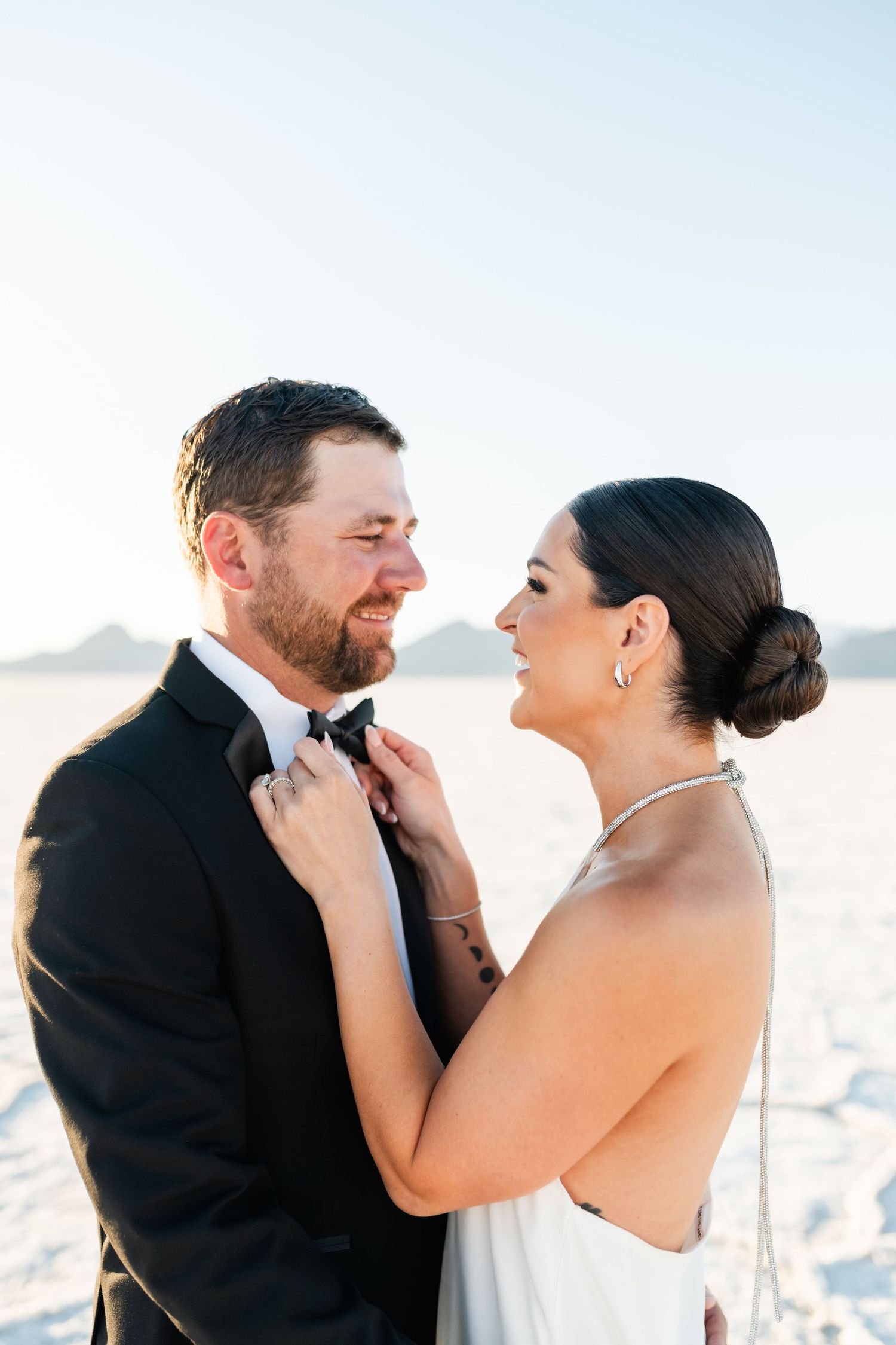 Salt Flats Photographer. A romantic moment between a couple on their wedding day against a bright sky background.