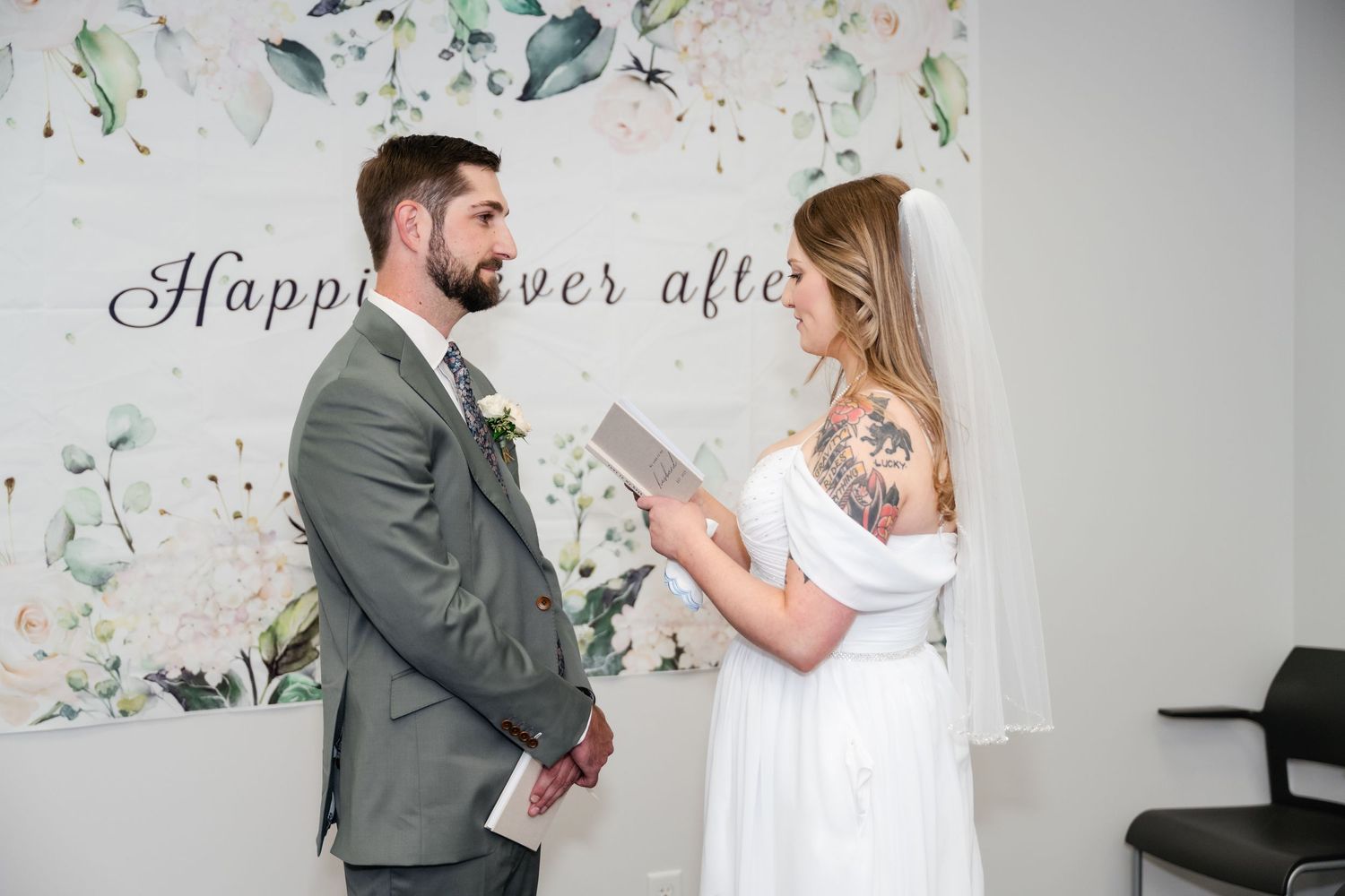 A couple in wedding attire share a romantic moment surrounded by falling confetti and floral decorations.