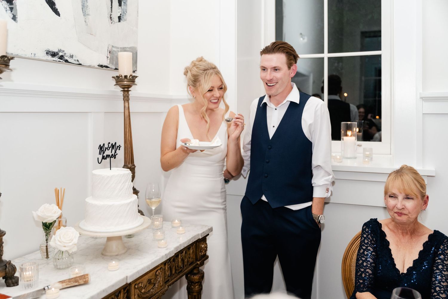 Wedding celebration candid moments in bright white venue with elegant decor.
