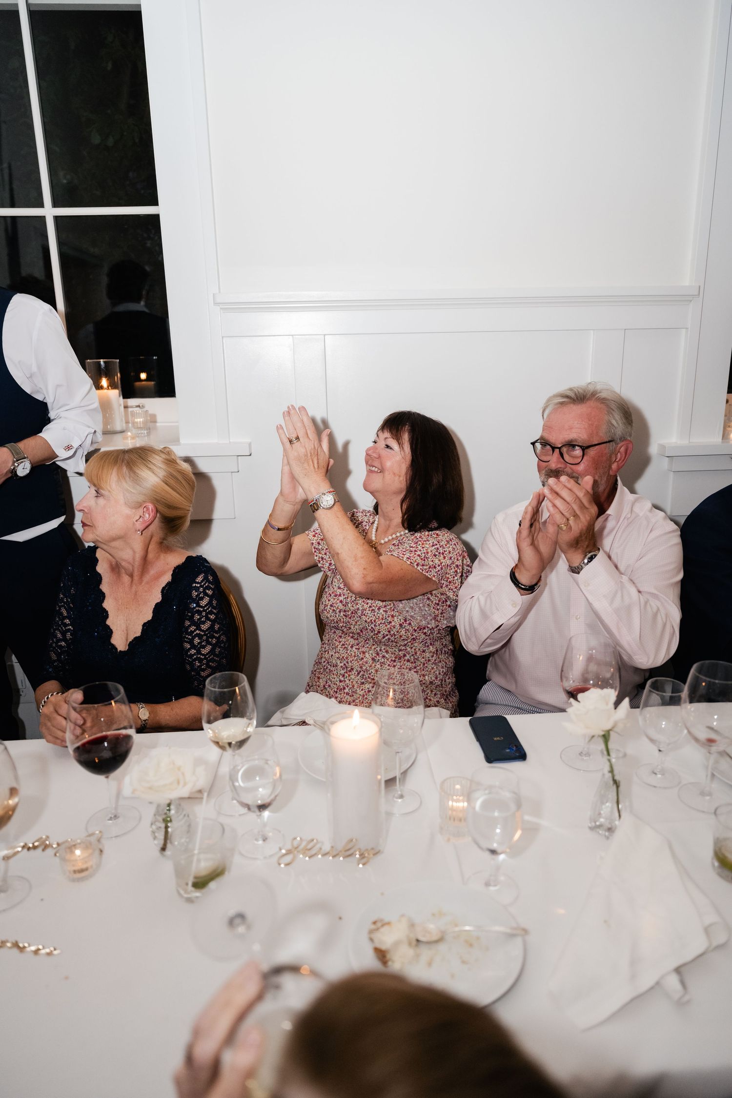 Wedding reception guests react with surprise and delight during dinner celebrations.