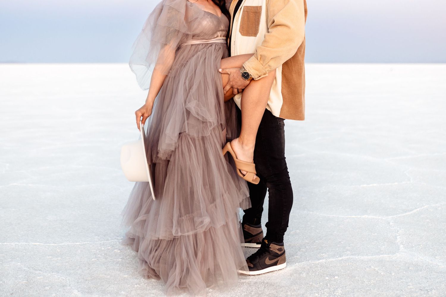 Couple hold each other during Salt Flats photos by Utah couples photographer during sunset